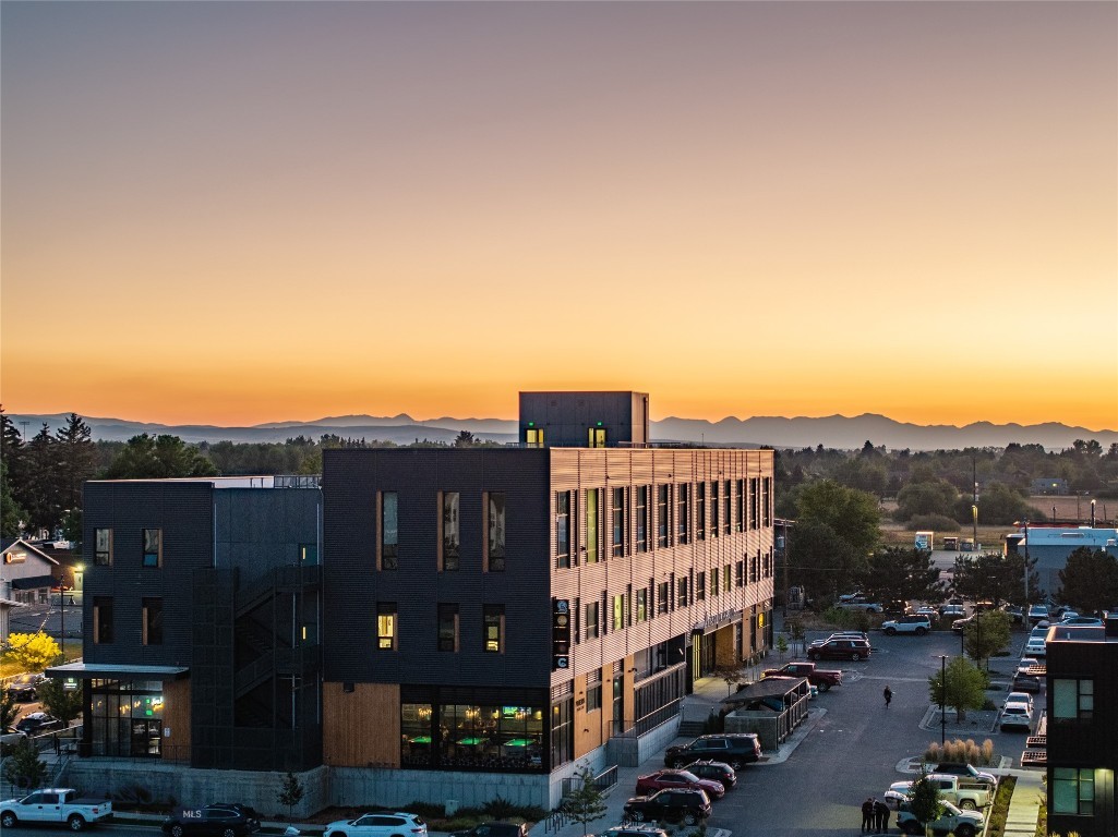 Big Bridger views, upgraded finishes, and a central Bozeman address define this newer 2BD/2BA condo just off N 7th Avenue, steps to restaurants, breweries, coffee, the fairgrounds, concert venue, and bike park. A sunlit, open living/dining/kitchen showcases an exposed brick wall, an upgraded appliance package, and a stunning custom gas fireplace, the only unit in the building to feature one; a striking wood-and-steel staircase leads to the lofted primary suite with a well-appointed bath, in-unit laundry, and a generous walk-in closet. The lower level offers a second bedroom and a 3/4 bath. Enjoy the rooftop deck, fabulous for entertaining and taking in mountain vistas. Several units in this building have proven mid-term rental history. Buyer to verify rental eligibility, permitting, and HOA rules.