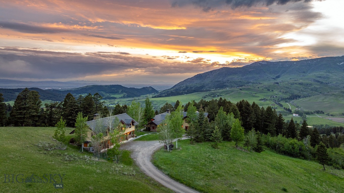 Presented to the market for the first time, this is the rare convergence of architectural mastery, absolute privacy and a setting so breathtaking it must be experienced to be believed. A true legacy estate set on 31+ acres at the top of Bridger Canyon, panoramic views of multiple mountain ranges and the sweeping valley below form a backdrop that cannot be replicated. An expansive outdoor patio extends the living space, offering a vantage point for that privacy and those views in every season. The main residence offers 3 bedrooms and 3.5 baths across 5,270 sq ft, built to a standard of craftsmanship that is the work of Matthew Beardsley as architect/contractor, with open timber framing by Timberworks of Gallatin Gateway, fir beams, doors and detailing throughout, and custom wrought iron fixtures throughout the main house and guest house by acclaimed blacksmith Bill Moore. The price includes all furniture, artwork and furnishings currently in the house (with few exceptions), including specialty pieces: glassware by Simon Pearce, dishware by Grand Canyon China, and flatware by Lisa Jenks. The kitchen is appointed for serious entertaining: a Wolf 60" range, Wolf wall oven, Sub-Zero freezer drawers, Fisher & Paykel dishwashers, dual beverage fridges, a wine fridge, commercial hood, and a custom banquette — each detail considered. Whole-home systems include central vacuum, in-floor radiant heat, a roof melt system, and AV/alarm infrastructure. Throughout, art lighting illuminates' walls designed for display, complemented by indirect up-lighting that lends a quiet glow to every room. Floor-to-ceiling windows frame the mountains and valley from every direction, making the landscape a constant presence indoors. Warmth follows the same generosity, with custom stone and masonry wood-burning fireplaces in the main residence, guest house and on outdoor patio. Positioned above the generously sized 3-car garage — which includes a separate space suited for a shop — the guest residence offers 2 bedrooms and 2.5 baths across 1,980 sq ft, outfitted with Wolf appliances, central AC, and offering the same elevated standard as the main home. A custom shuffleboard table anchors a separate space built for games & group fun. Properties of this caliber — privately held, impeccably built, and set against Montana's most coveted panoramas — rarely come to market, making this one of the finest offerings in the state.