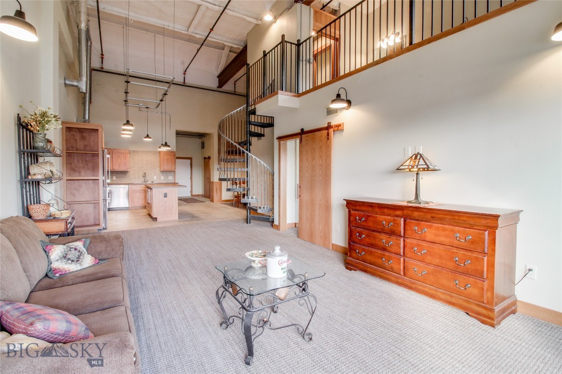This sleek 1,659+/- sq. ft. condo in the Billings Industrial Revitalization District offers 1 bedroom, 2 bathrooms, and a versatile loft space. Featuring vaulted ceilings and stunning Red Oak trims, this home provides an open and bright atmosphere. The gourmet kitchen includes Bosch 800 Series appliances, a gas range, custom-built cabinets, and tile flooring. Enjoy sweeping views from the spacious living room and large balcony. Amenities include a gym, theater, pet park, and secure underground parking with elevator access. The environmentally friendly VRV heat pump system ensures year-round comfort. Monthly CAM fees: $235.98. Buyer/ Buyers agent to verify.