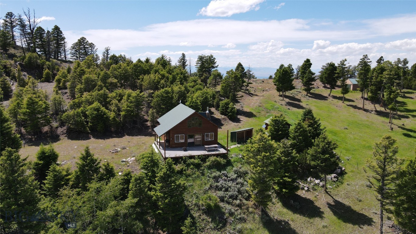 Experience top of the world views from Copper Mountain in the heart of SW Montana's premier big game hunting areas. This property consists of two adjoining mining claims with 37.5 acres combined and borders BLM lands. Very well constructed set of improvements sit at about 7200 feet in elevation and include - spacious cabin with open and covered decks offering panoramic vistas of surrounding mountains, detached sauna and bath house, storage barn/garage, and solar/generator shed. All off grid, no well- water is hauled to the site. The main cabin (offered furnished) provides 4 separate sleeping areas, kitchen, living room with wood stove, dining area, and storage. The shop/barn has horse pasture fence around it if you want to bring your horses to hunting camp.