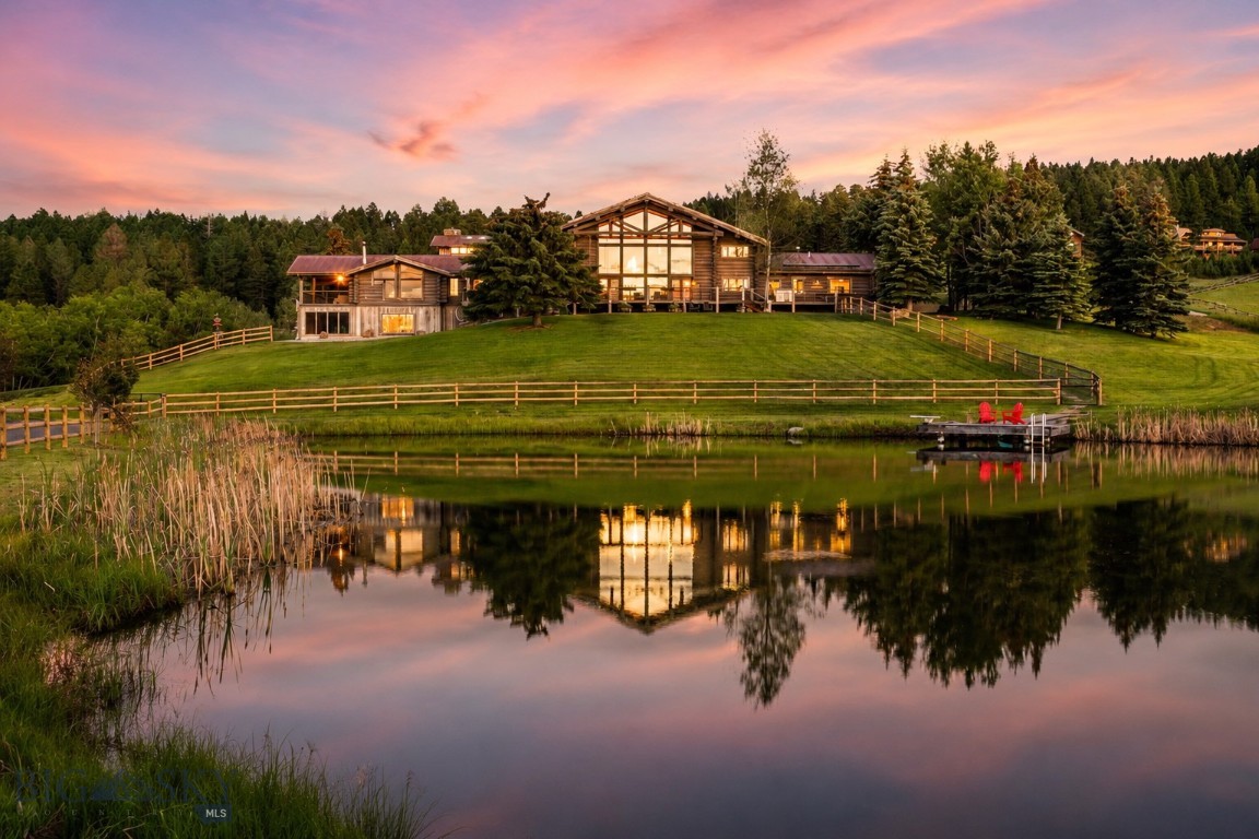 Set amidst nearly 30 acres of mature aspens, open meadows, private trout waters, and exceptional equestrian amenities in the coveted Jackson Creek area of Bridger Canyon, Incognito Ranch embodies the very best of Montana living.  Incognito Ranch is more than an estate—it is a collection of experiences. Ride horses through your own private preserve, cast a line into the stocked trout pond, explore trails winding beneath towering aspens alongside a seasonal creek, and take in panoramic views of the Bridger and Bangtail ranges. At the heart of the property is an impressive 8,185± square foot lodge-inspired residence, thoughtfully refreshed throughout and designed to embrace its stunning surroundings. Towering windows frame mountain vistas in every direction, while soaring ceilings, natural materials, and curated finishes create an atmosphere that is both sophisticated and inviting. The main-level primary suite lives as a private retreat with a sitting area, wood-burning stone fireplace, spa-inspired bath with copper soaking tub, custom closet, covered balcony, and mountain views. The main level also includes two additional bedrooms connected by a Jack-and-Jill bath, a stately great room with floor-to-ceiling windows, and a beautifully appointed kitchen featuring brand-new Taj Mahal quartzite countertops and backsplash, walk-in pantry, and temperature-controlled wine and whiskey room. Upstairs offers an additional bedroom, full bath, and library/media room, while the walkout lower level features a family and game room with kitchenette, sauna, fitness area, bunk room, and screened porch. Complementing the residence is an attached 765± square foot art studio/guest apartment, along with approximately 3,810± square feet of heated garage and shop space featuring epoxy floors, extensive storage, an auto lift, workshop, and pull-through bays. Equestrian amenities are equally impressive. The thoughtfully designed barn complex is anchored by a beautifully appointed luxury guest house. Additional improvements include a five-plus stall barn with tack room and wash rack, hay barn, two turnout paddocks with automatic waterers, two fenced pastures, and a 100' x 200' riding arena with specialized footing. Private, peaceful, Incognito Ranch offers a rare opportunity to experience luxury living & Montana's outdoor lifestyle just 15 minutes from downtown Bozeman, minutes to public land, and only 10 minutes from Bridger Bowl Skiing & CrossCut Mountain Sports.