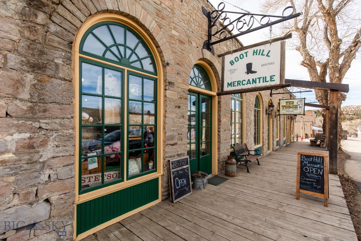 Step into ownership of Boot Hill Mercantile, ideally positioned on Wallace Street along Virginia City’s main commercial corridor with direct frontage on the historic boardwalk. Featuring genuine frontier charm and a proven retail operation, this offering includes the business, inventory, and real estate, presenting a rare opportunity in a market where private ownership is limited and opportunities like this are highly sought after. Originally home to The Madisonian newspaper, the building carries a rich legacy that is immediately felt upon entry. Set in the heart of Virginia City, this location places you among one of the most well preserved frontier communities in the American West. Original hardwood floors, vintage displays, and a striking stone exterior create an atmosphere that resonates with visitors seeking a true Montana experience. This is the kind of space that draws people in and keeps them browsing. Currently operating as a successful mercantile and gift shop, the business benefits from high volume seasonal tourism, strong foot traffic, and a location that captures the flow of visitors exploring Virginia City’s boardwalks, historic theaters, and gold rush era landmarks. The approximately 1,971± sqft layout is functional and inviting, offering flexibility to continue the existing retail concept or introduce a new vision such as a specialty shop, gallery, café, or curated Western brand. Recent updates include the addition of a bathroom in the rear portion of the building, where there is currently a storeroom. This creates the potential for employee accommodations or housing, adding another layer of functionality to support business operations. With its established presence, highly usable layout, and prime location, Boot Hill Mercantile is well positioned for an owner-operator or investor looking to step into Virginia City’s tourism driven economy. Surrounded by recreation, history, and a stream of visitors from across the country and around the world, this property is positioned to capture the energy of one of Montana’s most visited historic destinations. This property offers more than just income potential. It offers a place in a destination known far beyond Montana for its preserved history and authentic visitor experience. Shown by appointment only. Contact your agent to schedule a private tour and experience this opportunity firsthand.