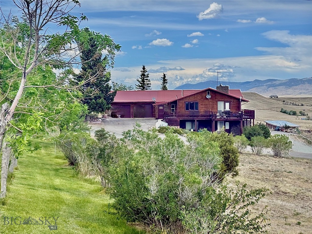 A MONTANA LIFESTYLE awaits you in this beautiful log home, with wrap around deck, overlooking 21 acres with peaceful mountain views. Great location near the small town of Whitehall, Montana. County living, less than 5 miles from I-90. Nice open floor plan with large windows that frame the scenery. Easy living with 3 bedrooms, two full baths, and a laundry room on the main floor. Enjoy additional space in the walkout basement which offers a recreation room with antique wood stove, another bedroom and bath, a walk-in pantry, and garage. A second attached garage provides room for all your vehicles and toys. The acreage is gorgeous - with chokecherry bushes, mature trees and bushes, and a lovely apple tree. The bunnies love this area and there are underground sprinklers to keep everything green. A fenced pasture, with a loafing shed and corral, make this the ideal Montana ranchette. Near the 30,000-acre Pipestone Off-Highway Vehicle recreation area for fun and adventure, with hot springs accommodations too. County living with everyday essentials in nearby Whitehall. Only 30 miles away, the 'Lady of the Rockies' is overlooking the historical town of Butte. In Butte, you will find a variety of restaurants, medical care, anchor stores, and an international airport. The increasingly popular Bozeman is ~60 miles to the east and the ever-popular Yellowstone National Park is only ~120 miles from home. Call your agent today to schedule a showing of this Montana gem.
