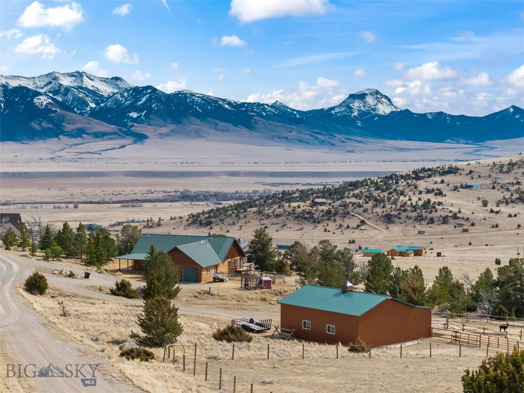 Experience true Montana living with this stunning 1,955 sq ft log home nestled on 7.89 scenic acres in Shining Mountains. Surrounded by breathtaking views of the Madison Range, this property offers the perfect blend of comfort, functionality, and outdoor adventure. The home features a warm and inviting interior with vaulted ceilings and beautiful cedar walls and ceilings, creating a classic Montana log home feel. The spacious kitchen is equipped with newer appliances including a GE 5-burner gas stove, farmhouse sink, and a functional island with storage, making it ideal for everyday living and entertaining. The primary suite is generously sized, featuring a private walkout to a deck, an ensuite with a jetted corner tub, walk-in shower, and large walk-in closet. Two additional guest bedrooms share a full bathroom, and the home offers ample storage throughout.
Recent updates add peace of mind, including a new furnace and water heater installed in October 2025, along with new shades in the living area. Stay comfortable year-round with propane forced air heat (1000-gallon buried tank) and a cozy propane gas fireplace. A good-producing well adds to the property's practicality. Outside, the property is thoughtfully set up for animals and recreation. Approximately 2 - 3 acre pastures are fenced for horses or livestock, along with a separate fenced yard for dogs. Equestrian and hobby enthusiasts will appreciate the 30x40 enclosed barn (built 4 years ago) with a 10-ft overhang and metal roof, along with a greenhouse built just 2 years ago and raised garden beds. Additional features include a 2-car garage with built-in storage, established landscaping, and a unique mix of trees, shrubs, and rock outcroppings that enhance the land’s natural beauty. As part of the Shining Mountains community, enjoy private access through a locked gate to Haypress Lakes and adjoining state land, offering endless opportunities for hunting, fishing, horseback riding, hiking, and outdoor recreation. Conveniently located about 20 minutes from Ennis, known for world-class fly fishing on the Madison River and approximately 1 hour to Bozeman, providing access to shopping, dining, and the airport. This is a rare opportunity to own a turnkey horse property with privacy, views, and access to some of Montana’s best recreation.