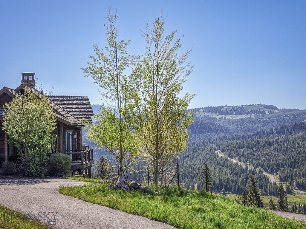 This rare opportunity represents one of the most exceptional homesites within the Ranch Neighborhood, offering a level of privacy, views, and natural beauty that is truly difficult to replicate. This homesite consists of 2.95 acres and is adjacent to more than 80 acres of protected open space. This remarkable property enjoys a uniquely secluded setting while remaining conveniently connected to the world-class amenities of the Club as well as the vibrant Town Center. Designed to accommodate both intimate family living and large-scale entertaining, this exceptional five-bedroom, four-and-a-half-bath residence with a dedicated office offers the convenience of primarily single-level living while providing ample space for family and guests. The thoughtfully designed floor plan features a spacious main-level primary living experience, while the lower level serves as a private retreat complete with four additional guest bedrooms, a bunk area, and an inviting secondary gathering space with wet bar. The lower level also includes seamless access to an outdoor hot tub, creating the ideal setting to unwind after a day on the slopes, golf course, or trails. One of the home's most inviting gathering spaces is the covered outdoor living area tucked just off the kitchen on the east side of the residence. Centered around a wood-burning stone fireplace offers a warm and welcoming setting to enjoy Montana's mountain lifestyle in every season. From this sheltered vantage point, you can enjoy the tranquility of the surrounding landscape as resident elk frequently pass through the adjacent open space.  Overhead radiant heaters take the chill off crisp alpine evenings, creating a comfortable environment for outdoor dining, cocktails, or simply relaxing with family and friends.
Positioned to capture breathtaking 180-degree panoramic views, the home enjoys some of the most spectacular sightlines in the community. The combination of expansive views, thoughtful design, and exceptional guest accommodations creates a mountain retreat that is as functional as it is unforgettable.
Quite simply, no other Ranch lot offers the rare blend of protected surroundings, panoramic vistas, and enduring privacy that defines Ranch Lot 1. A Golf or Social Membership is available with this residence.