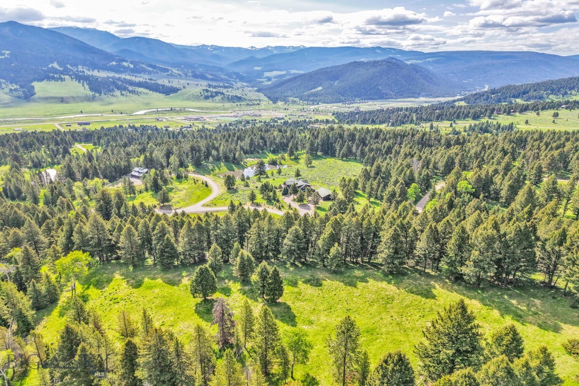 Discover the perfect balance of peaceful Montana living and easy access to Big Sky’s world-class amenities. Set on 20 private acres with sweeping views of the Gallatin Range, this exceptional property offers a true sense of retreat without sacrificing convenience. The main residence features 4 bedrooms, a dedicated office, and a spacious lower level complete with a game room—ideal for entertaining or relaxing. An indoor/outdoor dog kennel, attached two-car garage, and a separate heated three-car garage with a workout room provide modern comforts with rustic elegance. Horse lovers will be drawn to the impressive two-story barn, outfitted with five stalls, a tack room, workshop, and drive-through access. Above, you'll find a beautifully appointed one-bedroom guest apartment with a full kitchen, bathroom, and laundry room—perfect for visitors or extended stays. Enjoy serene moments paddling on the pond, hiking the trails on property, or watching for local wildlife. All of this is just minutes from the slopes, shops, and dining of Big Sky. This is more than a home—it’s a recreational paradise and a rare Montana sanctuary.