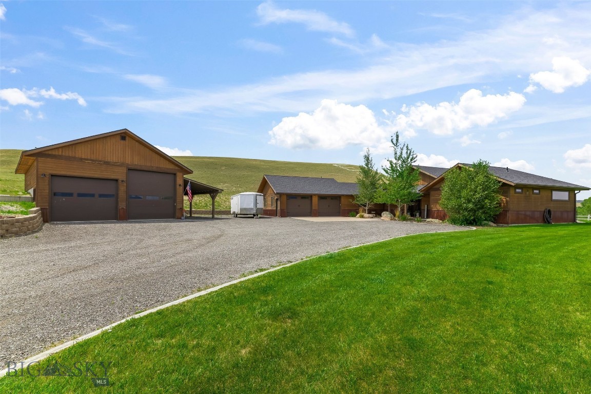 Experience the perfect blend of Montana luxury, privacy, and breathtaking scenery with this exceptional custom home situated on two adjoining parcels totaling approximately 5 acres. Built in 2018 and thoughtfully updated, this beautifully maintained 2,700± sq. ft. residence offers 3 bedrooms, 2.5 bathrooms, an office/flex room, and quality craftsmanship throughout. The open-concept floor plan is designed to capture stunning mountain views, featuring soaring vaulted ceilings, expansive windows, a striking moss rock veneer fireplace, and circle-sawn hickory hardwood floors. The spacious kitchen is both beautiful and functional with alder soft-close cabinetry, granite countertops, a large pantry, and generous workspace for entertaining or everyday living. The primary suite has been completely remodeled, creating a luxurious retreat with a beautifully updated bathroom and the convenience of a washer and dryer located within the walk-in closet. A second laundry area on the opposite side of the home adds flexibility for guests or family. Two guest bedrooms share a Jack-and-Jill bathroom, while the updated half bath showcases an elegant marble countertop. Fresh interior paint and all new carpet make this home truly move-in ready. Outdoor living is just as impressive, with multiple covered and uncovered patios perfectly positioned to enjoy panoramic views, abundant wildlife, and Montana sunsets. The landscaped yard features underground sprinklers for easy maintenance. In addition to the attached two-car garage, the property includes a heated 30