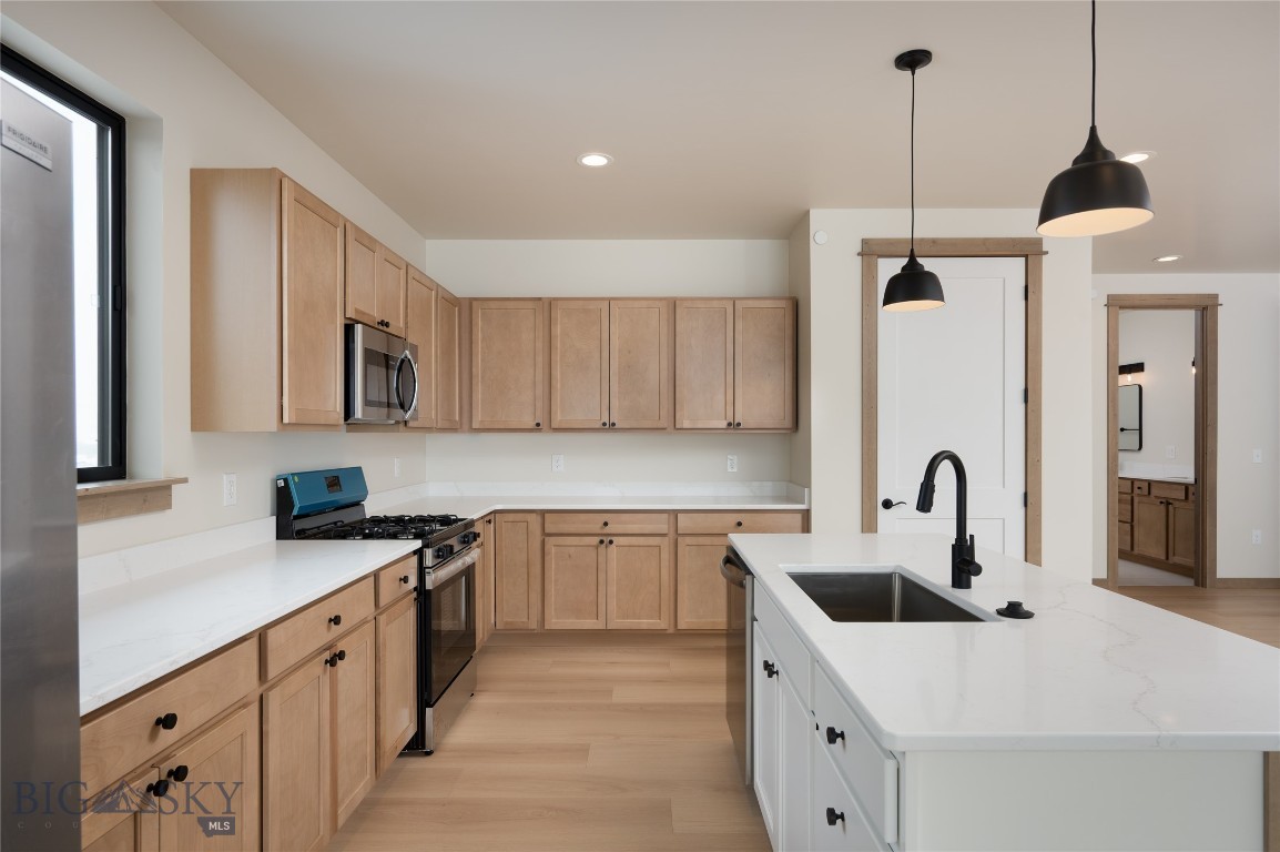 Introducing the Cottonwood Series at Fremont Square—a thoughtfully designed live/work residence offering the flexibility of commercial functionality paired with elevated residential living in one of the Gallatin Valley’s fastest-growing corridors. Positioned along Jackrabbit Lane with premium frontage and visibility, this unique floor plan was designed for owners who want to combine lifestyle, workspace, storage, and long-term investment into one property. The ground level features approximately 1,500 square feet of shop and garage space with a rare pull-through configuration, allowing easy access for vehicles, trailers, equipment, or business operations directly from the Jackrabbit frontage side. An additional shop bathroom and dedicated mechanical/storage area create functionality for a wide range of uses. Upstairs, approximately 1,400 square feet of residential space offers a completely different experience—private, comfortable, and designed to capture expansive Bridger Mountain views from the balcony side of the home. The open-concept kitchen, dining, and living area creates an ideal setting for entertaining or everyday living, while two spacious bedrooms—including a primary suite with walk-in closet and ensuite bath—deliver the comfort of a traditional residence. Whether used as a primary residence, office headquarters, lock-and-leave Montana basecamp, creative workspace, or storage solution with living above, the Cottonwood Series offers exceptional flexibility in a location with easy access to Bozeman, Big Sky, Yellowstone International Airport, and the surrounding Gallatin Valley.