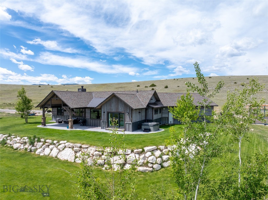Unmatched views stretch from beyond Sphinx Mountain to Ennis Lake from this end-of-road setting overlooking the winding Madison River near Varney Bridge. Bordering a large family ranch, this 15.82-acre property offers privacy and quiet while remaining close to the amenities of Ennis. It is rare to find a home with such proximity to town and virtually no homes in the viewshed. This custom 3-bedroom, 2.5-bath home (approx. 2,377 SF) was built in 2020 by Sphinx Mountain Builders—known for combining rustic design with modern craftsmanship. Built by the builder for his own family, it features high-end finishes throughout, including skip-sawn, wire-brushed white oak floors and a floor-to-ceiling flat willow moss rock wood-burning fireplace. The kitchen includes hickory cabinets, quartzite countertops, a large island, and a gas stove, opening to the great room and dining area oriented to capture sweeping Madison Range views. The mudroom and laundry area provide generous storage and workspace. The primary suite offers an office area, double-sink vanity, large soaking tub, oversized shower, and walk-in closet. Two additional bedrooms and a guest bath are located at the opposite end of the home. Exterior materials include flat willow moss rock, Montana Timber Products siding, and steel wainscoting for durability and clean lines. A covered patio with stamped concrete and curved beams creates inviting outdoor living space, complemented by an irrigated lawn and mature trees. The finished three-bay garage provides ample space for vehicles and equipment. This is the first time this property has been offered for sale—an excellent opportunity to own a custom home in a premier Madison Valley location.