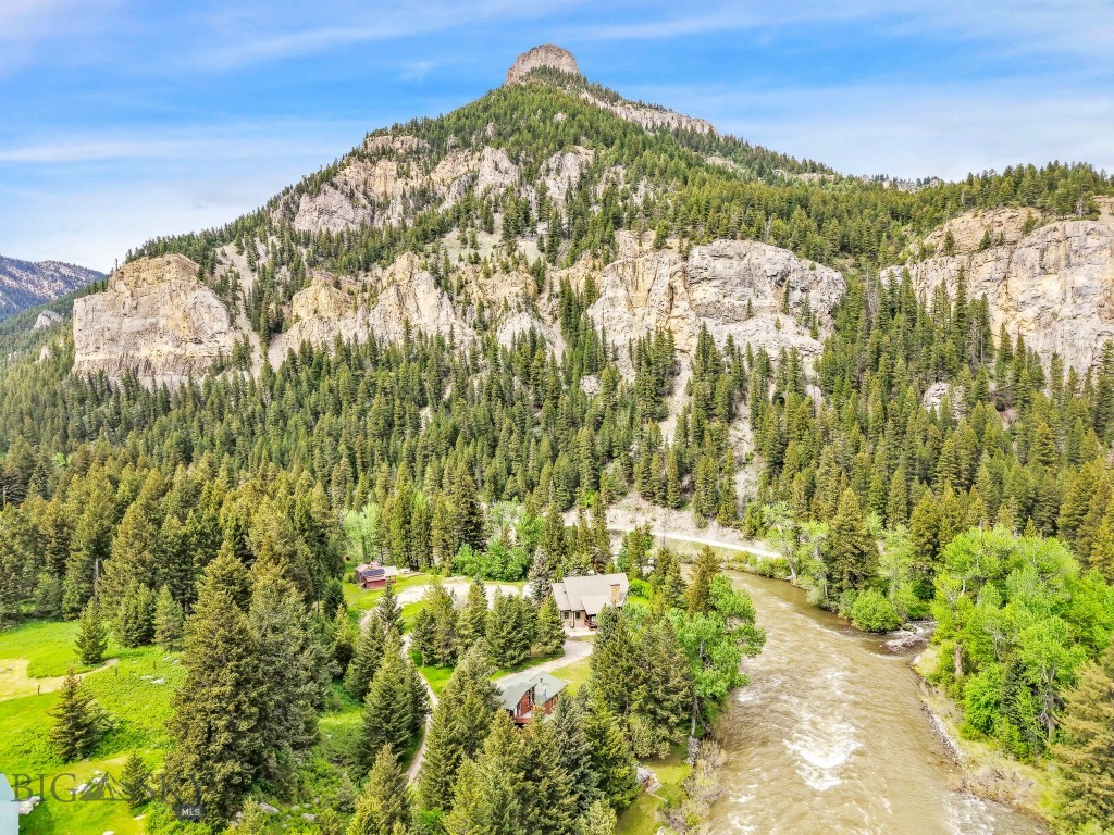 Rare Gallatin River Frontage. Nearly ½ Acre. Iconic Montana Setting.  Sitting along the banks of the legendary Gallatin River, this cherished family cabin sits on two separate parcels totaling approximately 0.49± acres of premier Montana riverfront property. With direct Gallatin River frontage, this offering is a speical opportunity to own a private stretch of blue-ribbon trout water in one of Southwest Montana’s most sought-after recreational corridors. “A River Runs Through It” was filmed just beyond the back door, an enduring testament to the breathtaking beauty and cinematic landscape that surrounds you. Fish world-class waters steps from your cabin, with Storm Castle Creek joining the Gallatin just downstream. Launch a raft or kayak upstream and float home to your own riverbank. After a day on the water, unwind in the sauna, relax by the fire, or simply take in the sights and sounds of the river flowing past your property. The cabin exudes rustic Montana charm. A wood-burning fireplace anchors the living area, while a vintage wood stove adds warmth and character to the kitchen. Featuring two bedrooms and one-and-a-half baths, the layout is comfortable and inviting, perfect as a recreational retreat, rental opportunity, or family cabin ready to create amazing memories.  Located minutes from Big Sky, Bozeman, and endless public lands, this property offers year-round access to fly fishing, rafting, hiking, skiing, and adventure. If you’ve been searching for authentic Montana riverfront real estate with privacy, history, and unmatched access to the Gallatin River, this is a truly rare find. Come experience the magic for yourself.