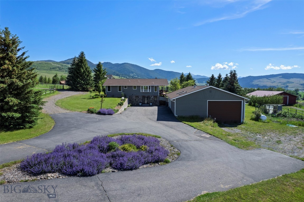 Located in picturesque Gallatin Gateway on a quiet road with exceptional mountain views, this 5-acre property offers privacy, open space, and expansive Montana skies. Designed for both comfort and versatility, the setting captures the essence of Montana living with peaceful surroundings, star-filled nights, and room to live, work, and recreate.

This versatile 4-bedroom, 3-bath home is well suited for multi-generational living, rental income potential, or equestrian use. The upper level features two bedrooms, two baths, a bright kitchen, and an inviting living area anchored by a wood-burning fireplace, along with washer and dryer hookups. The lower level includes two additional bedrooms, one bath, a laundry room, a large storage area, and plumbing in place for a future full kitchen, creating an ideal secondary living space. A propane fireplace adds comfort and functionality.

Recent improvements include new Andersen windows, new exterior siding, and fresh interior paint and trim, giving the home a clean and updated feel.

The property is fully equipped for both work and recreation. A 1,500 sq ft four-bay garage with an RV bay includes an office, dog kennel and run, and generous storage. Equestrian amenities include a 1,500 sq ft heated pole barn with four stall bays, horse-safe fencing, heated horse water, instant hot water heater, and an insulated tack room or office with its own meter and transformer, plumbed for propane. The barn also presents strong potential for conversion to a second dwelling with stunning mountain views.

Additional features include two loafing sheds, a chicken coop and run or fenced garden area, and a fire pit for outdoor enjoyment. Protective but flexible covenants allow for short-term rentals, a guest house, and up to five horses. The HOA provides access to a nearby private 15-acre park with a riding arena, trails, and creek crossings. Ideally located with convenient access to Bozeman and world-class recreation at Big Sky Resort, along with year-round opportunities for skiing, fishing, hiking, and horseback riding.

Whether you are seeking a full-time residence, an equestrian property, a multi-generational retreat, or an investment opportunity with income potential, this property offers a rare combination of flexibility, infrastructure, and Montana lifestyle in one setting.