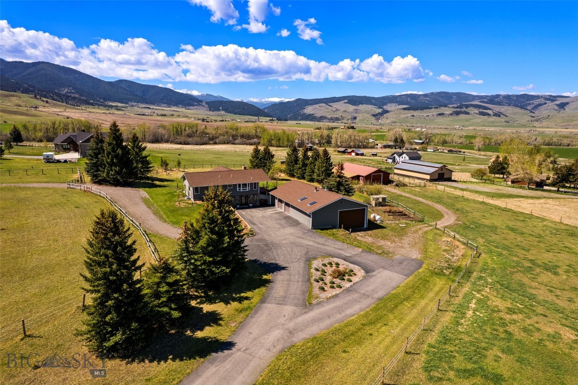 Located in picturesque Gallatin Gateway on a quiet road with exceptional mountain views, this 5-acre property offers privacy, open space, and expansive Montana skies. Designed for both comfort and versatility, the setting captures the essence of Montana living with peaceful surroundings, star-filled nights, and room to live, work, and recreate.

This versatile 4-bedroom, 3-bath home is well suited for multi-generational living, rental income potential, or equestrian use. The upper level features two bedrooms, two baths, a bright kitchen, and an inviting living area anchored by a wood-burning fireplace, along with washer and dryer hookups. The lower level includes two additional bedrooms, one bath, a laundry room, a large storage area, and plumbing in place for a future full kitchen, creating an ideal secondary living space. A propane fireplace adds comfort and functionality.

Recent improvements include new Andersen windows, new exterior siding, and fresh interior paint and trim, giving the home a clean and updated feel.

The property is fully equipped for both work and recreation. A 1,500 sq ft four-bay garage with an RV bay includes an office, dog kennel and run, and generous storage. Equestrian amenities include a 1,500 sq ft heated pole barn with four stall bays, horse-safe fencing, heated horse water, instant hot water heater, and an insulated tack room or office with its own meter and transformer, plumbed for propane. The barn also presents strong potential for conversion to a second dwelling with stunning mountain views.

Additional features include two loafing sheds, a chicken coop and run or fenced garden area, and a fire pit for outdoor enjoyment. Protective but flexible covenants allow for short-term rentals, a guest house, and up to five horses. The HOA provides access to a nearby private 15-acre park with a riding arena, trails, and creek crossings. Ideally located with convenient access to Bozeman and world-class recreation at Big Sky Resort, along with year-round opportunities for skiing, fishing, hiking, and horseback riding.

Whether you are seeking a full-time residence, an equestrian property, a multi-generational retreat, or an investment opportunity with income potential, this property offers a rare combination of flexibility, infrastructure, and Montana lifestyle in one setting.