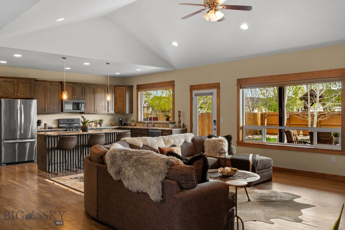 Set on one of the best lots in Gallatin Heights, this super charming, custom-built home by Chamberlain Builders offers direct access to one of the neighborhood parks right out your back gate, along with beautiful Spanish Peaks views from the covered back patio and Bridger Mountain views from the front. You’re welcomed by a warm entry that opens into the living room and flows seamlessly into a bright, open kitchen designed for easy living and entertaining, featuring custom black walnut cabinetry, quartz countertops throughout, a gas range, large windows that bring in great natural light, and a door leading straight out to the covered patio. The living room is anchored by a gas fireplace with a stunning custom black walnut mantel and vaulted ceilings that continue into the primary bedroom, adding warmth and character to the space. Just off the kitchen, a spacious mudroom and laundry room connect to the heated three-car garage, offering excellent storage and everyday functionality. The layout lives like a single-level, with the primary suite tucked privately on one side of the home featuring its own patio access, dual walk in closets with custom built-ins, and a generous ensuite with quartz countertops, black walnut cabinetry, a tile shower, soaking tub, and split vanities. Black walnut cabinetry continues throughout all bathrooms in the home. Two additional bedrooms and a full bathroom are also located on the main level. Upstairs, you’ll find a versatile bonus space or guest retreat complete with a full bathroom, perfect for visitors, a media room, or a quiet escape. With central A/C, a great-sized lot, access to trails and multiple parks within the community, and convenient proximity to the airport, Big Sky, and downtown Bozeman, this home brings together comfort, location, and lifestyle in all the right ways.
