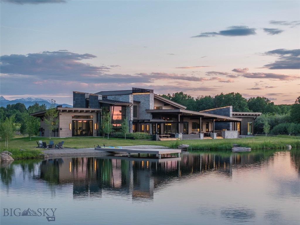 Welcome to Lightfell—Where light, land and water meet and life slows down. This premier Montana estate offers the perfect fusion of functional modern luxury and a deep connection with the 20 acres of land located just 10 minutes from downtown Bozeman. Completed in 2024 by Centre Sky Architecture and Bridger Builders, this remarkable property features over 13,200 SF of living space - 7,600SF of interior living with a 5,655 SF, 3-bed main residence, a 1,990 SF, 4-bed guest home and 5,600+/- SF of outdoor living spaces, plus, a 5,300 SF shop and sportsman’s lounge—all crafted for elevated everyday living and effortless entertaining. Every detail of the main home has been meticulously designed, from floor-to-ceiling windows framing panoramic views of four mountain ranges that surround the valley to the tranquil sight lines over your private 3-acre, stocked pond. Enjoy seamless indoor-outdoor living with heated patios, a sunken hot tub, outdoor gas fireplace, built-in grills, and beautifully manicured lawn and landscaping. Inside, the 3-bedroom main home features a sanctuary primary suite with vaulted ceilings, fireplace, spa-inspired bath with soaking tub and tile shower, and a generous walk-in closet complete with island and private laundry. An open-concept Great Room with temp-controlled wine gallery, home gym, two additional ensuite bedrooms and fenced raised garden beds round out this thoughtfully curated residence. The 4-bedroom guest home is ideal for hosting, offering two identical wings—each with a spacious large bedroom and bunk room—joined by a comfortable central living area. Guests can enjoy privacy without sacrificing connection. The 5,300 SF heated shop is a dream setup for Montana’s outdoor lifestyle. Two pull-through bays including one with 14'x15’ doors and an additional door to accommodate RVs, toys, and gear. Inside, the Sportsman’s Lounge provides a rustic gathering space with kitchenette, gas stove, and built-in safe. Additional amenities include a dog wash station, washer/dryer, and an upper level game room with billiards, foosball, and shuffleboard completed by a rooftop deck offering sweeping views of the Bridgers—perfect for summer sunsets or starry nights. This rare offering delivers privacy, space, and five-star living in one of Bozeman’s most exclusive neighborhoods with abundant wildlife and Bozeman Creek access.