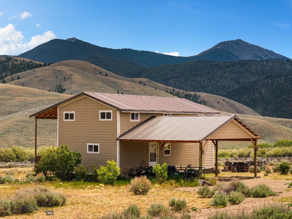 The rustic Polaris cabin you've been waiting for! Set on 2.35 acres in the heart of the Pioneer Mountains, this cabin offers scenic views in every direction, including a direct shot of the Sawtooth Mountains, Grasshopper Valley and Maverick Mountain Ski Area. Whether you're looking for a year-round residence, weekend getaway or basecamp for outdoor adventure, this property is ready to enjoy!

The main level features a cozy living room, adorable kitchen, 1 bedroom, 1 full bathroom and an office space that has been used as a sleeping area. Upstairs offers 2 more bedrooms (one room does not have a closet), a 3/4 bathroom and covered balcony access with panoramic mountain views that will have you outside taking in the views and fresh mountain air until the sun goes down. Whether you warm up by the pellet stove after a day of outdoor adventures or enjoy a nice evening around the outdoor fire-pit, this is the kind of place where it's easy to slow down and enjoy the mountains.

Designed for practicality over fanciness and for those who appreciate outdoor adventures, the property provides easy access to skiing, snowmobiling, hiking, fishing and endless recreation, with subdivision access to Grasshopper Creek just moments away. After a day exploring the mountains, come home to a warm and inviting cabin where you can grill and relax on the covered deck or unwind on the upper-level covered balcony while taking in the incredible scenery.

Pull up and park under the attached carport, which has plenty of room for outdoor toys, and store your gear in the storage shed. There's also a small, dry cabin with a wood stove that could be transformed into an adorable guest cottage or rec room. A golf-cart truckster is included in the sale to help maintain the property, along with select furniture, making this mountain getaway even easier to enjoy from day one. Rustic, comfortable and surrounded by some of Southwest Montana's most spectacular scenery, this is a place where many memories are waiting to be made.
