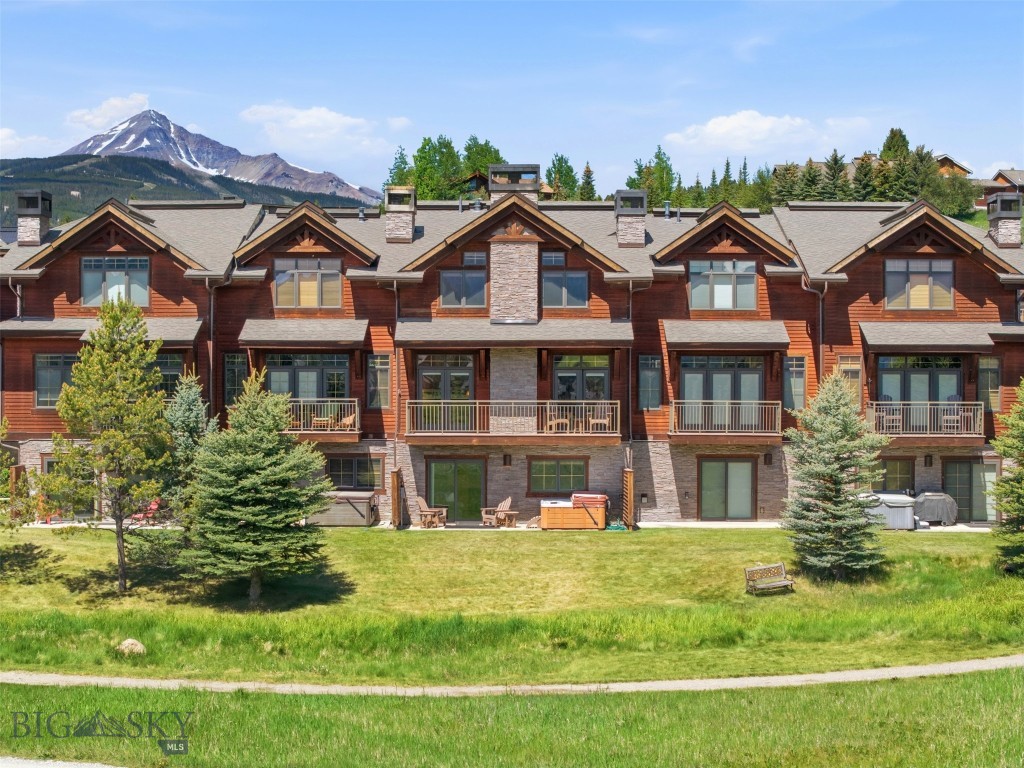 This beautifully updated Spanish Peaks Club Condominium offers a rare opportunity to own one of the most desirable residences in the community. Selected by the current and original owners prior to construction from the available units in the development, this exceptional unit backs to open space and enjoys unobstructed down-valley views, providing a unique combination of privacy, scenery, and convenience. Meticulously maintained and never rented, it is being offered fully furnished and move-in ready. Ideally located in Big Sky's Meadow Village, the property provides direct access to Big Sky's trail system, with Nordic skiing & snowshoeing in the winter and hiking and biking in the summer. The neighborhood clubhouse, fitness center, and outdoor pool are just steps away, while Town Center, the Meadow Village, golf course amenities, parks, tennis and pickleball courts, and countless recreational opportunities are all within walking or biking distance. The highly sought-after "C" floor plan is the largest in the complex and is widely regarded as the best layout. All four bedrooms are generously sized, complemented by three full bathrooms. The spacious kitchen, dining, and living areas are designed for gathering and entertaining, with room for everyone around a single, custom dining table. A wood-burning fireplace creates a warm mountain ambiance, while abundant storage includes an oversized entry, walk-in pantry, laundry/mechanical room, built-in closet systems throughout, and a heated two-car garage.Numerous upgrades set this residence apart, including wood flooring throughout with no carpet, slate flooring in the lower-level hallway, custom cedar stair risers, upgraded plumbing fixtures and custom glass shower enclosures, one-inch granite countertops in all bathrooms, in-ceiling speaker wiring, and enhanced stair rail detailing. An additional highlight is the abundance of nearby guest parking, making it easy to host family and friends—an uncommon feature in Big Sky. After a day on the trails, golf course, or ski slopes, relax in the private hot tub overlooking the open space and peaceful surroundings. Never rented and lovingly cared for by its original owners, this is a truly exceptional offering in one of Big Sky's premier condominium communities.