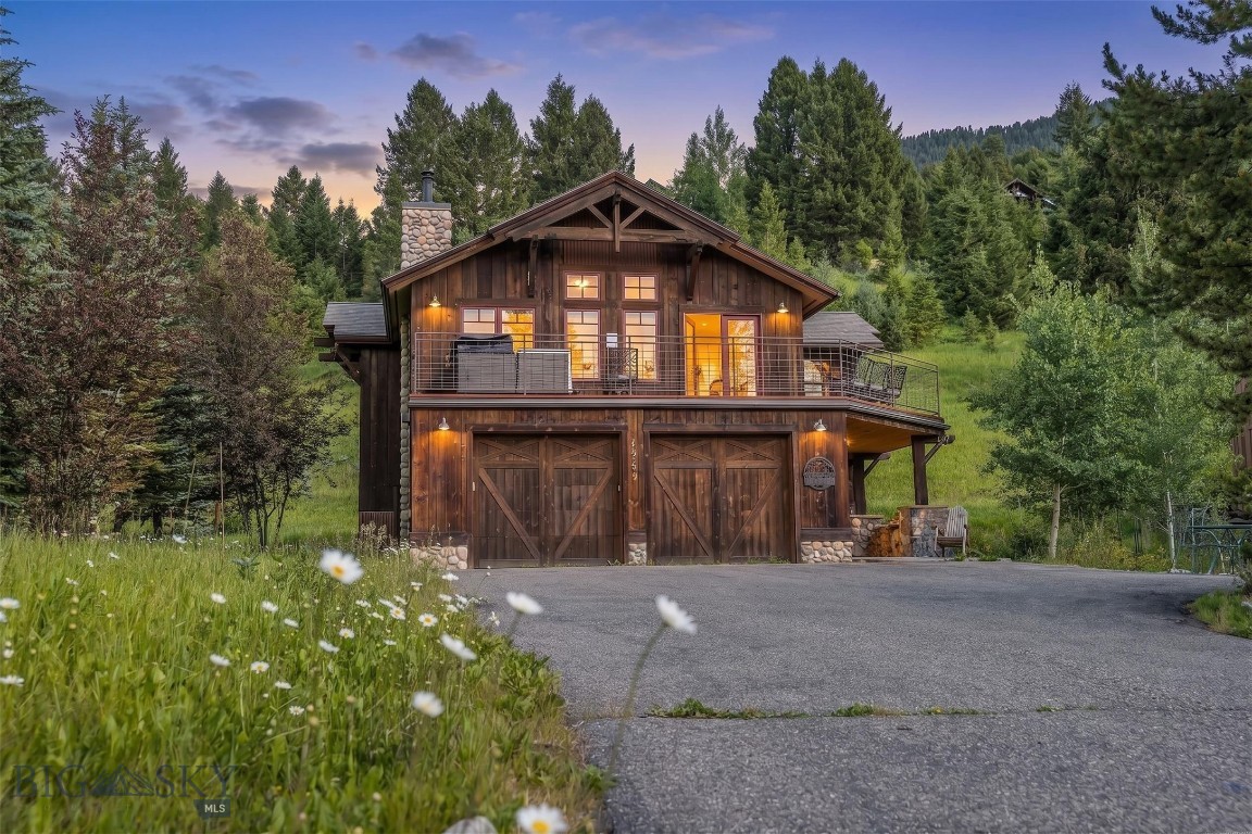 The Big Sky Meadow Village lies just below Lone Peak, and this home on Little Coyote Road holds a south-facing position near its center. Mountain views, a wrap-around deck, and afternoon light that lingers on the surrounding peaks. Natural wood and river rock masonry anchor the home with the mountain esthetic that draws people in. Inside, radiant heat runs beneath the floors, a wood-burning fireplace anchors the main living area, and two separate living spaces allow a household to gather or retreat to recharge after a day well spent outside. Four bedrooms, three bathrooms, beautiful outdoor space, and an attached two-car garage sized for the gear a Montana year demands. What surrounds the house matters as much as the house. Big Sky Community Park is a short walk from the door, with tennis and pickleball courts, newly built baseball and soccer fields, a volleyball court, disc golf, playgrounds, and river trails for hiking and biking. The cross-country ski system begins across the street. The Big Sky Golf Course sits at the edge of the meadow, and Big Sky Town Center, with its restaurants, markets, and summer concert series, is minutes away. Winter mornings start on the trails across the road or up on the mountain of Big Sky Resort. Summer evenings end on the deck.The wider geography is the second proposition. Big Sky Resort's world-class skiing sits fifteen minutes up Lone Mountain Trail. Yellowstone National Park is forty-five minutes south. Bozeman Yellowstone International Airport and the historic Main Street of downtown Bozeman are an hour north through the Gallatin Canyon, with the Gallatin River running alongside the drive the entire way. Turnkey and ready as it stands. A full-time home for a family in the mountains, a retreat for the seasons that matter most, and a rental that works in the weeks between.