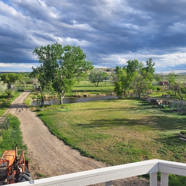 Previous buyer could not sell their home while renting, made many updates during their time in the property. Welcome to your new home that is ideal for horses, livestock and even bison! It combines the best of all worlds with an easy and commutable distance to Great Falls and enough property to support your agricultural needs. This listing includes 4 already divided lots, a total of 12.23 acres, with a slough AND it abuts the renowned 406 Arena trails. The 406 attracts horse people from around the world and the trails are in your back yard. Enjoy sturdy fences, since the seller keeps bison on the property now, stunning butte views and a sophisticated stock watering system. The home is a classic ranch style with two bedrooms and a full bath upstairs and a non-egress lower living room, bedroom, and a 3/4 bathroom. On the main level, there is an enormous, and genuine stone, wood-burning fireplace and the living room boasts tongue and groove pine ceilings and walls. City water AND a well, community sewer, natural gas.  
Enjoy a detached two/car garage, a shed and a barn-inspired "person cave,” that has an upstairs with a deck and a main floor space that could be converted to corrals or retained as additional storage. Metal roofs; steel siding. Original hardwood floors on the upper level. Gas stove in lower level. You'll love the big, covered deck off the kitchen, with views. Grass lawn around the house. Bay window in the kitchen.