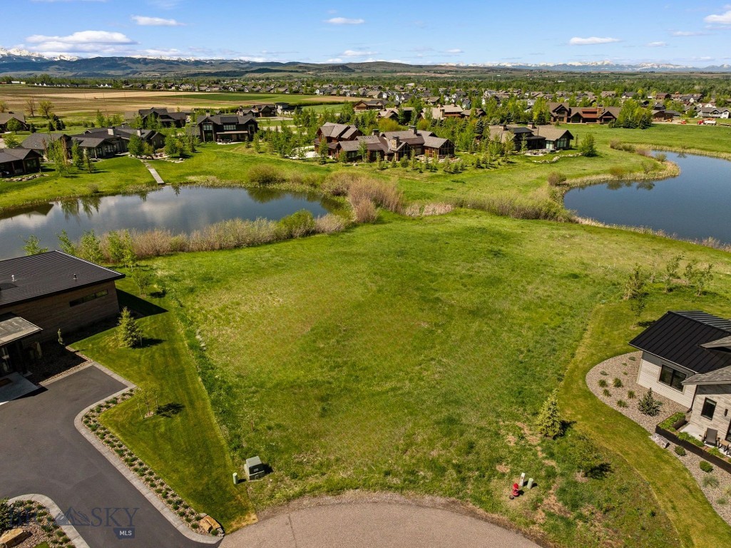 Positioned at the end of a quiet cul-de-sac within the prestigious Black Bull Golf Community, this exceptional homesite offers a rare opportunity to build on one of the last remaining and most desirable lots in the community. Backing to open community acreage and adjacent to two large ponds, the property captures peaceful views of meadows, water, and surrounding mountain ranges with a sense of privacy that is truly unmatched. Spanning just over one half of an acre, the lot is level and build-ready, with community water, sewer, natural gas, and paved access already in place, and allows for a stately main residence up to 8,500 square feet. Its premier location features a quiet backdrop, enhanced privacy, and an ideal setting to design a truly custom residence. With extensive site work already completed as well as the opportunity to obtain advanced architecture plans from a premier Bozeman firm, this Montana homesite is the perfect canvas for your dream residence. Black Bull is one of Bozeman’s most sought-after communities, centered around a private golf course and offering resort-style amenities including a pool, fitness center, clubhouse, and dining. Situated just minutes from downtown Bozeman, the Bozeman Yellowstone International Airport, and endless outdoor recreation, this is a rare opportunity to create your Bozeman masterpiece.