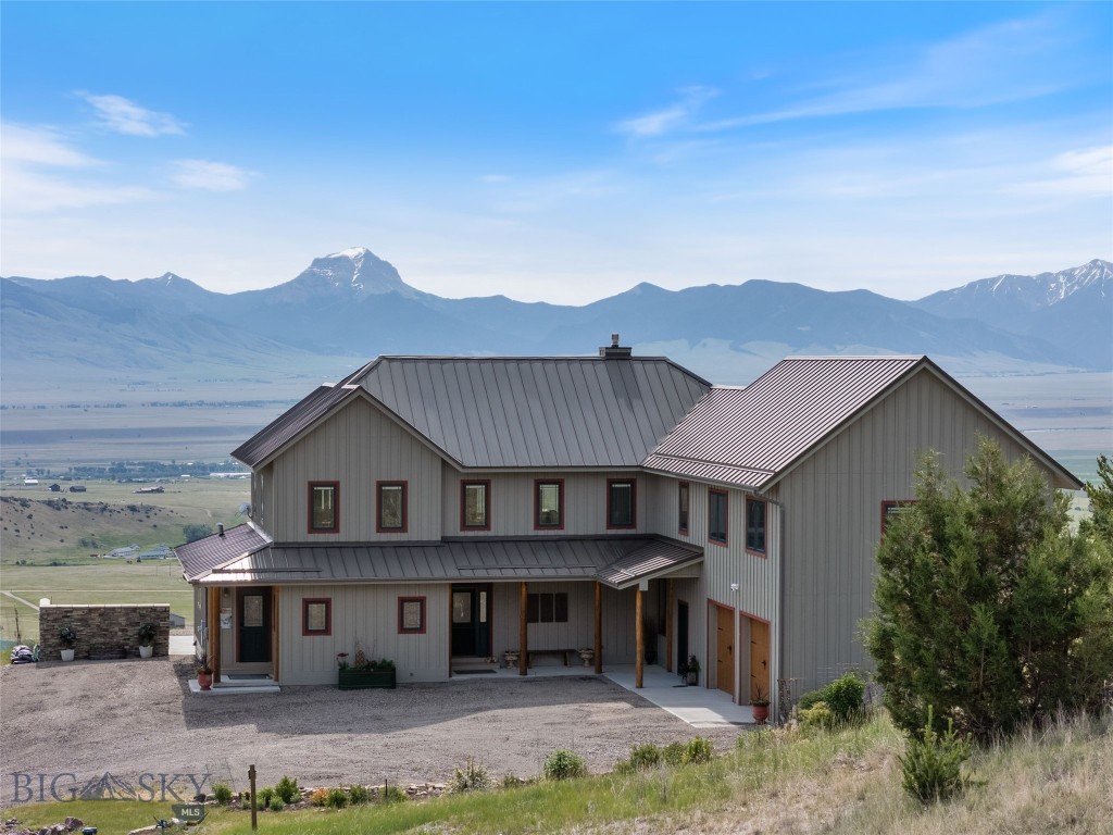 BEING SOLD COMPLETELY TURN KEY! Perched on a private hillside with sweeping, unobstructed views of the Madison Range, this exquisite custom home offers unmatched craftsmanship, energy efficiency, and Western charm. Built with SIP construction and solar panels that feed directly into the grid, this thoughtfully designed 5,244 sq ft residence brings monthly electric bills down to an average of $5 a month. The beautifully landscaped grounds feature mature trees, perennial flower beds, thoughtfully placed shrubs, and stunning rock gardens that blend effortlessly into the natural terrain, enhancing the property’s serene and private setting. Inside, you'll find alder wood doors and trim throughout, a gourmet kitchen with cherry cabinetry, granite counters, two ovens, and a walk-in mudroom with laundry and pantry space. The main living area showcases vaulted ceilings, a floor-to-ceiling rock gas fireplace, and triple-pane Pella windows and doors with built-in blinds opening to a maintenance-free deck and hot tub. The primary suite offers panoramic views, private deck access, a walk-in closet, double vanity, walk-in shower with custom glass door, and a separate toilet room. Upstairs, the “Cowboy” guest room shares a Jack & Jill bath with a cozy media room featuring a showstopping barn door made from reclaimed mine wood. A second spacious guest room connects to the game room and shares a bath with dual vanities, while a third oversized guest suite includes its own private bath. Additional highlights include a gravel grate and wrought iron stair banister, radiant in-floor heat in both house and garage, three mini-splits for heating and cooling, two water heaters, two boilers, air exchange system, whole-house water softener, and a finished shop space off the two-car garage. Offered fully furnished and impeccably appointed, including all art, décor, kitchenware, linens, and towels. This residence presents a truly turnkey opportunity. Simply arrive with your suitcase and immediately enjoy refined Montana living at its finest. This one-of-a-kind Montana home combines comfort, luxury, and sustainability in a truly spectacular setting. Located just minutes from the charming town of Ennis, around an hour to Bozeman, and within easy reach of Yellowstone National Park, this property offers peaceful seclusion without sacrificing access to world-class recreation, dining, and amenities.