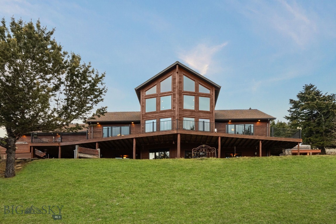 Your timeless Montana mountain retreat awaits in this stunning 4,280 sq ft custom home set on 13 pristine acres at approximately 6,000 feet in elevation. Positioned along the edge of a peaceful valley, this property offers a rare and immersive wildlife experience—where elk, deer, and native birds are frequent visitors, and each day feels like a private escape into nature.

Designed across three levels with 23 foot soaring ceilings, including a dramatic loft, the home is anchored by a striking south-facing wall of glass that captures natural light and frames sweeping sunset views beyond downtown Bozeman—visible right from your deck. The main level features an expansive kitchen, dining area, and a luxurious primary suite complete with a private deck and hot tub overlooking the mountain landscape.

Exceptional craftsmanship is showcased throughout, beginning with 6-inch hand-scraped birch flooring in the kitchen, knotty alder doors, and matching alder window, door, and baseboard trim. The kitchen features rustic hickory cabinetry, which continues throughout all bathrooms, as well as the mudroom, wine closet, and workshop. Locally harvested Douglas fir—sourced within two miles—has been crafted into the kitchen countertops and fireplace mantel, while exposed beams and stacked support posts add architectural character from the basement through the great room to the loft.

Warm finishes continue with pine tongue-and-groove ceilings in the great room and downstairs bedrooms, a custom cherry bookcase in the loft, travertine tile in the primary bath, slate in the entryway, and barnwood accents in the bunk room. The lower level offers a spacious living and game room with walk-out access to a firepit and tranquil water feature.

Outdoor living is equally impressive, with cedar siding, sandstone steps and walkways, and a stone fireplace seating area. High-quality Jeld-Wen windows and patio doors bring in light, while a dual heating system with Lennox forced air and radiant heat ensures comfort.

A detached, heated 1,100 sq ft shop—currently used as a professional woodworking space—offers flexibility for hobbies, storage, or gear, with room for vehicles and toys. Conveniently located just 28 minutes from Main Street Bozeman, 38 minutes to Bridger Bowl, and 30 minutes to Livingston, with access to ATV trails in the Bangtail Mountains, this property offers the perfect balance of seclusion, accessibility, and elevated mountain living.