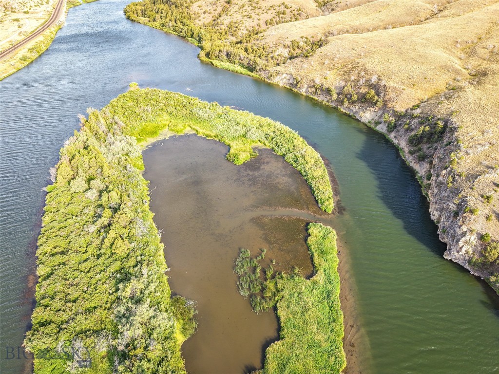 This unique property in Broadwater County, Montana offers a rare opportunity to own a heavily vegetated island tract with significant waterfowl habitat and direct Missouri River access. Located approximately three river miles upstream of the Toston Dam and a public boat launch, the parcel is well-positioned for seasonal recreational use. Its shallow water cove, mature foliage, and established cover make it an attractive option for waterfowl hunters and wildlife observers. Remnants of an old duck blind can be seen within the island's shallow water cove telling a long forgotten story of past waterfall hunts on this unique offering. The island provides natural shelter and food sources for ducks, geese, and other species that frequent the Upper Missouri River Basin. Public lands on the adjacent riverbanks also provide additional boat/raft launch points and areas for outdoor activity and seasonal access to fishing, hunting, and hiking.

The tract's heavy vegetation consists of native grasses, shrubs, and mature riparian trees that contribute to excellent concealment and habitat value. This same foliage creates a barrier of seclusion, ideal for recreation. Access is by boat or watercraft during appropriate seasons, as the parcel is surrounded by the flowing river channels. With private ownership of island properties becoming increasingly scarce in the Western U.S., this property stands out for its location and proximity to hubs like Bozeman and Helena. The land is undeveloped and lends itself well to low-impact recreational uses. This stretch of river is known for trout and walleye angling opportunities. Please note that the land has frequent flood potential and actual acreage is dependent on erosion and water levels. While the legal description says 12 acres, the land above the high water line is substantially less. Please see links on the listing for Montana water law as it relates to navigable waters in the state.
- Private Island on Missouri River
- ~3 River Miles Upstream of Toston Dam
- Secluded water inlet for privacy and waterfowl hunting
- Lush grasses and riparian trees/foliage
- Flood plain, likely not suitable for permanent structure
- Trout and Walleye Opportunities