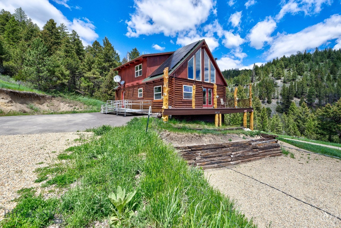 Welcome to 7210 Spring Creek Trail, a peaceful Montana retreat set on 20 acres and offering the perfect blend of off-grid living, natural beauty, and everyday comfort. This inviting log home features 3 bedrooms, 3 bathrooms, vaulted ceilings, a loft, and large windows that frame the surrounding meadows, views, and frequent wildlife. The main living area feels warm and open, with a propane heater and wood stove creating a cozy gathering space through every season. Whether you’re enjoying a quiet morning, watching wildlife move through the meadow, or settling in after a day outside, this home offers the kind of setting that feels both private and grounding. The property is truly special, with creek frontage, an upper spring that can feed a pond, a beautiful mix of trees and open meadow, and peaceful views in every direction. Additional improvements include two storage sheds, a tack area and barn, plus a covered chicken coop or critter area for your animals and hobbies. If you’ve been looking for a treed Montana property with water, wildlife, privacy, and room to enjoy a simpler way of life, this off-grid log home on 20 acres is a rare opportunity to make that dream your own. This property can be on the grid with power close however seller chose to keep it off grid. There are water rights to the 2 springs to fill the fish /wildlife permitted pond, Hunting and horses/livestock is allowed. A newly upgraded solar 48volt lithium power with generator backup that is plumbed to propane tank. A well thought out system for easy off grid living.