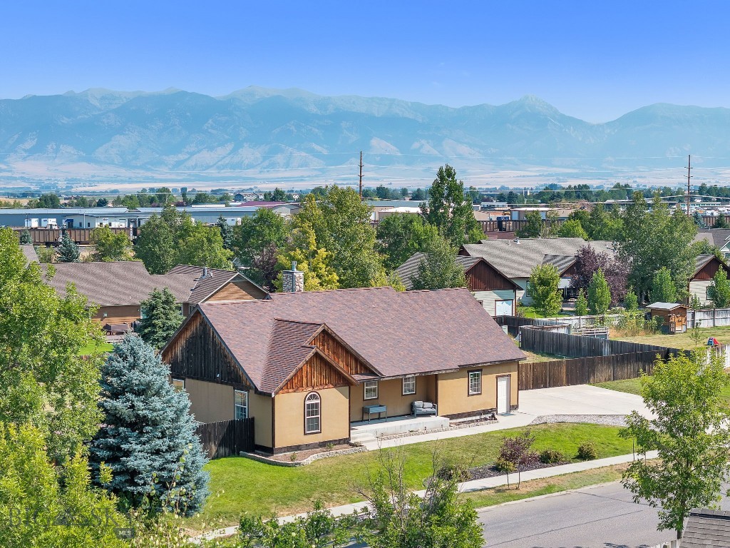 Welcome to one of Landmark Subdivision's most impressive offerings! This 5-bed, 3-bath home delivers over 3,000 SqFt of thoughtfully laid out living with the kind of finishes that actually earn the label. Vaulted ceilings, a stacked stone fireplace, hardwood floors, and a split bedroom floor plan, give the main level an easy, functional flow. The primary suite is privately positioned, framing sweeping Bridger Mountain views and features a custom walk-in closet and a spa like en suite, complete with double vanities, a jet tub, and a separate shower. There are two additional bedrooms and bathroom upstairs that provide flexibility for family or guests. The kitchen is built for real life, carefully selected appliances, generous cabinetry space, and a seamless open connection to the dining and living areas. Downstairs, the fun continues with a dedicated entertaining area complete with a wet bar, perfect for hosting. Two additional bedrooms, a bathroom, and a bonus room that adapts to whatever you need. Outside, the fully fenced .60-acre backyard is ready for outdoor gatherings with family and friends. Landmark lies just west of Bozeman and north of Yellowstone National Park. Surrounded by the Bridger, Spanish Peaks and Tobacco Root Mountain ranges, the area is home to world class fly fishing, snow skiing, hunting and other outdoor recreation. Move-in ready and loaded with character, this one is not to be missed.