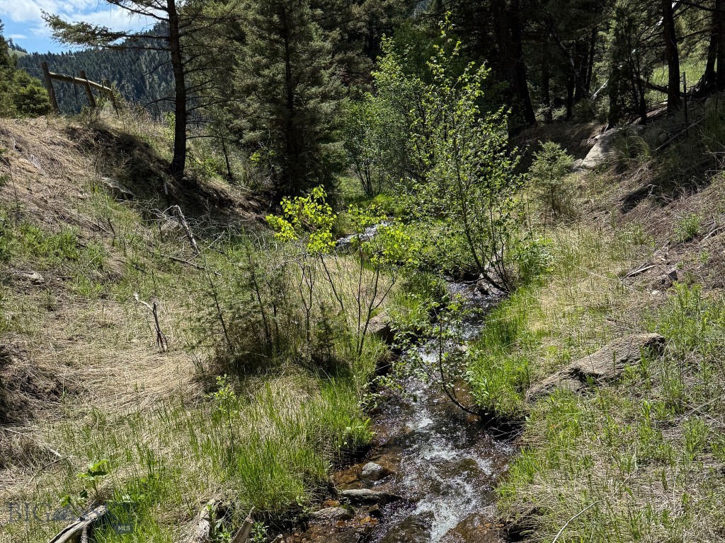 Don’t miss this amazing opportunity to own a beautiful mountain lot with year-round creek frontage, and power at county road. The property offers incredible hunting opportunities, with deer, elk, and bears frequently seen in the area and on the nearby public land. Outdoor enthusiasts will love the abundance of recreational activities in the area. You’ll be close to expansive BLM and Forest Service lands for hunting, surrounded by many creeks and rivers ideal for fishing. This parcel lends itself to an easy commute to Helena, Boulder, or Butte as it is about 1 mile from I-15's High Ore Exit. The seller will grant an easement with sale to get onto property from adjacent parcel/county road. The seller also has a bridge structure that they will negotiate on if buyer decides to cross the creek to their build site. A BLM "right of way" could be another viable option for a buyer to avoid crossing the creek.

This property is a patented mining claim, and seller's mineral rights convey with the sale. Affordable creek properties are not easy to come by, so don't miss your opportunity.