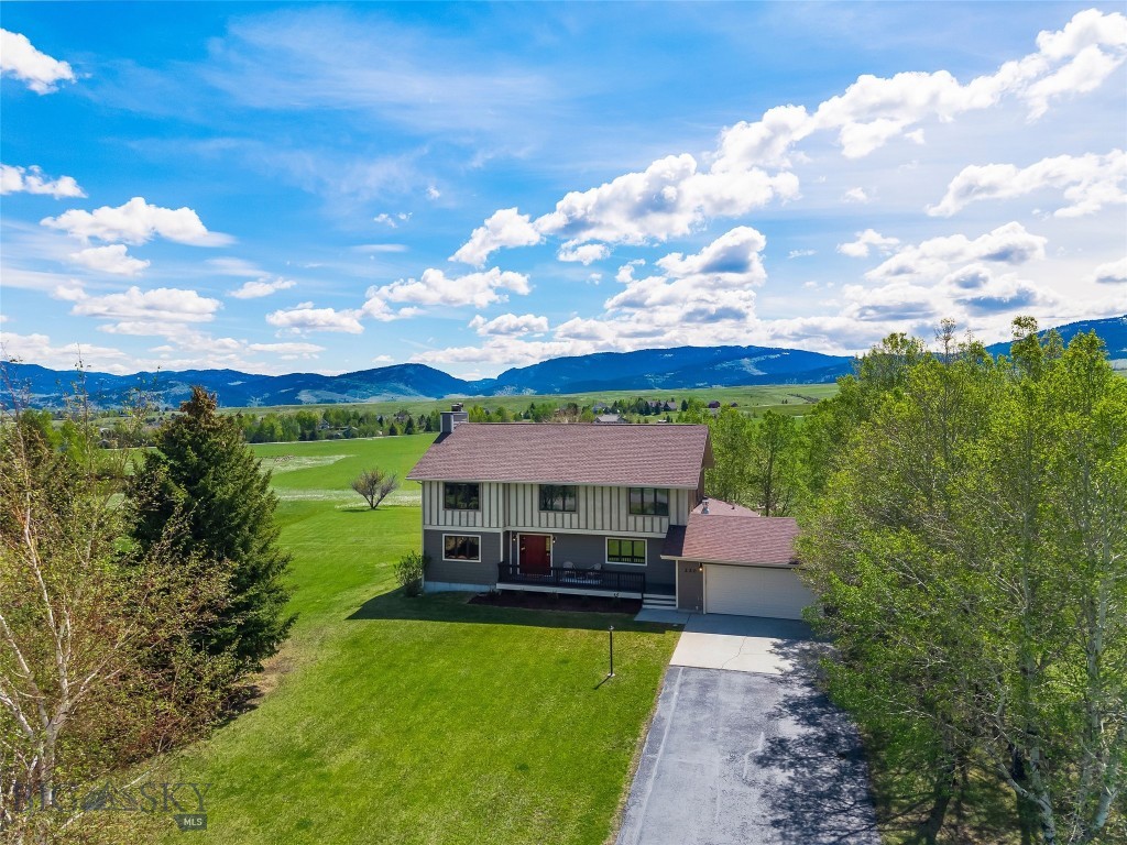 Perched atop Sourdough Ridge on a quiet cul-de-sac, this 3,721 square foot home occupies one of the most commanding positions in the Gallatin Valley. Set on 2.5 private acres with true 360-degree mountain views, the residence is perfectly oriented to its landscape: the Bridger Range framed from the living room and primary suite, with the Spanish Peaks, Gallatin Range, Tobacco Roots, Hyalite Range, and Mount Ellis filling every other window. Custom-built and rebuilt 14 years ago to its original mid-century footprint, the home has been lightly lived in since and is offered as a rare canvas for a discerning buyer. The main level is anchored by a wood-burning brick fireplace in the living room, a separate den with a gas fireplace and custom built-ins, and recently refinished decks that open to long Montana evenings. Upstairs, five bedrooms each frame their own view of the valley, mountains, and mature trees, with no two windows telling the same story, including a primary suite thoughtfully positioned to capture the Bridgers. The lower level extends the living space with a recreation room centered on a cast iron wood stove and stone surround, plus a full bath and generous unfinished square footage ready to be finished as a private guest suite, additional bedroom, or independent living quarters with a private entry. Beyond the home, refreshed landscaping and mature trees give way to open land, with ample room for horses, a barn, a shop, or future outbuildings. Central air conditioning and an attached two-car garage complete the offering. This setting is exceptionally rare in the expanding Bozeman area: 2.5 unrestricted acres, with no HOA and no covenants, ten minutes from downtown Bozeman and Montana State University, fifteen miles to Bozeman Yellowstone International Airport, and twenty miles to Bridger Bowl. More than a home, 220 Ridge Trail is a generational piece of the Gallatin Valley ready for its next chapter.