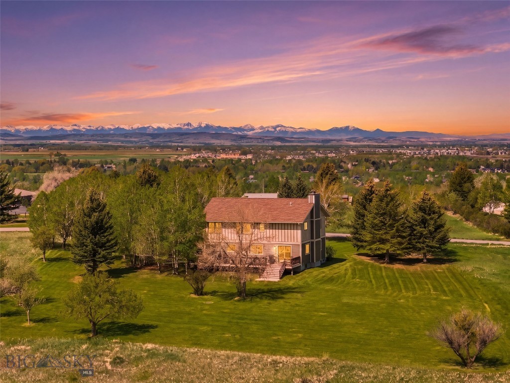 Perched atop Sourdough Ridge on a quiet cul-de-sac, this 3,721 square foot home occupies one of the most commanding positions in the Gallatin Valley. Set on 2.5 private acres with true 360-degree mountain views, the residence is perfectly oriented to its landscape: the Bridger Range framed from the living room and primary suite, with the Spanish Peaks, Gallatin Range, Tobacco Roots, Hyalite Range, and Mount Ellis filling every other window. Custom-built and rebuilt 14 years ago to its original mid-century footprint, the home has been lightly lived in since and is offered as a rare canvas for a discerning buyer. The main level is anchored by a wood-burning brick fireplace in the living room, a separate den with a gas fireplace and custom built-ins, and recently refinished decks that open to long Montana evenings. Upstairs, five bedrooms each frame their own view of the valley, mountains, and mature trees, with no two windows telling the same story, including a primary suite thoughtfully positioned to capture the Bridgers. The lower level extends the living space with a recreation room centered on a cast iron wood stove and stone surround, plus a full bath and generous unfinished square footage ready to be finished as a private guest suite, additional bedroom, or independent living quarters with a private entry. Beyond the home, refreshed landscaping and mature trees give way to open land, with ample room for horses, a barn, a shop, or future outbuildings. Central air conditioning and an attached two-car garage complete the offering. This setting is exceptionally rare in the expanding Bozeman area: 2.5 unrestricted acres, with no HOA and no covenants, ten minutes from downtown Bozeman and Montana State University, fifteen miles to Bozeman Yellowstone International Airport, and twenty miles to Bridger Bowl. More than a home, 220 Ridge Trail is a generational piece of the Gallatin Valley ready for its next chapter.