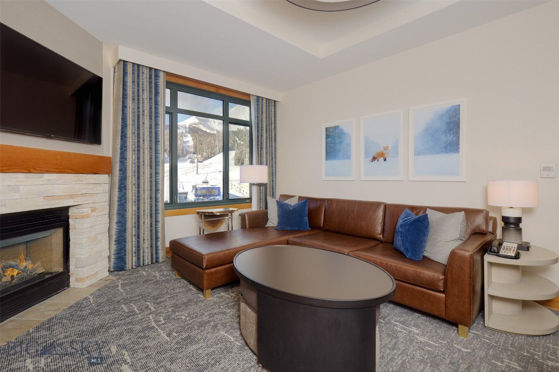Enjoy stunning Lone Mountain views from this newly remodeled two-bedroom condominium in the prestigious Summit Hotel/Condominium. Perfectly positioned beside the Ramcharger 8 and Swift Current lifts, this residence offers one of the best true ski-in/ski-out locations in all of Big Sky. This unique tri-hull floor plan features two bedrooms configured as three adjoining hotel rooms with interconnecting doors—an ideal layout for hosting family, friends, or rental guests. Sold fully furnished and turn-key, the spacious unit comfortably sleeps up to 10 people. The central room serves as the main living space, offering a kitchen, dining area, bathroom, and a cozy living room with a fireplace, Murphy bed, and fold-out sofa. One end suite functions as the primary bedroom, complete with a king bed, corner sofa, fireplace, wet bar, and private bath. The opposite end suite includes two queen beds, a wet bar, and a full bathroom. Enjoy full-service, four-star amenities including a newly renovated indoor/outdoor heated pool and spa, a Himalayan salt sauna, expansive fitness center, outdoor hot tub with mountain views, underground parking, on-site fine dining, and premium concierge and valet services—all designed to elevate your mountain lifestyle.