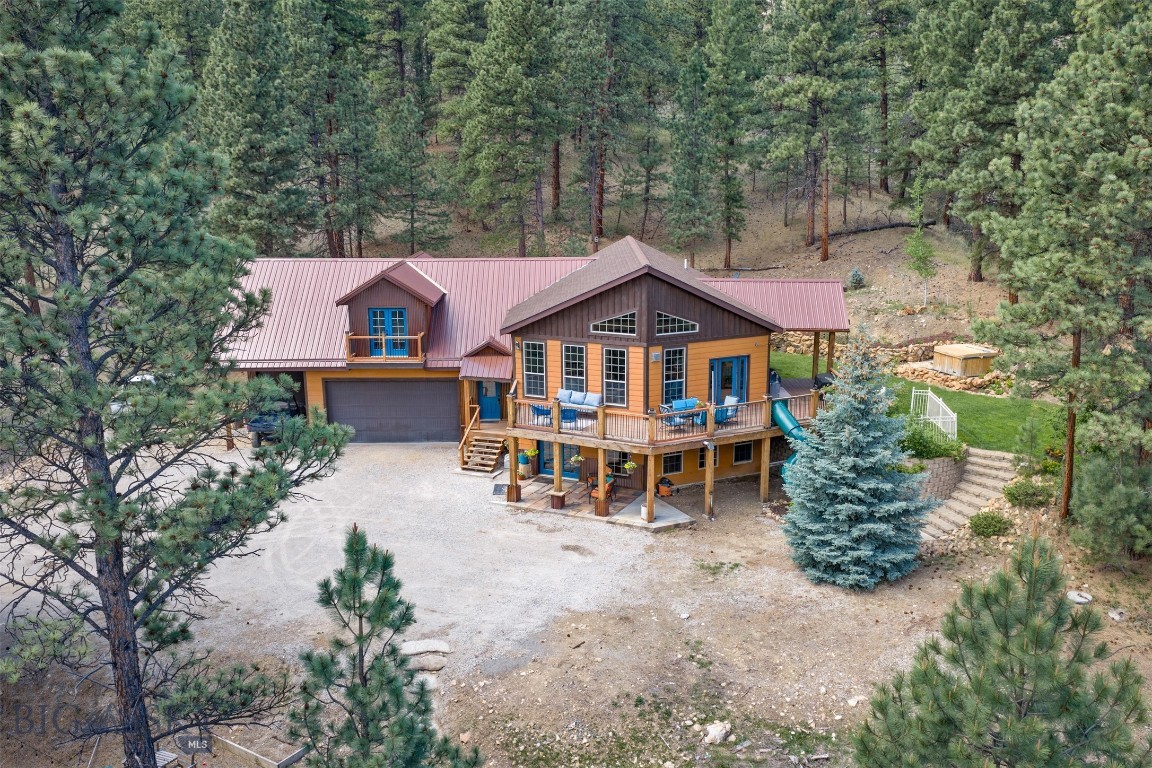 Escape to the mountains with this charming cabin retreat in beautiful Jefferson City on over 10 acres! Offering the perfect blend of comfort, functionality, and income potential, this unique property includes a spacious main home plus a separate guest apartment above the oversized (heated) 3-car garage.

The main level features a warm and inviting open floor plan with soaring windows that bring the outdoors in, a cozy gas fireplace, and an open kitchen, living, and dining area ideal for gathering with family and friends. The primary suite offers a walkthrough closet leading to the private ensuite bathroom, while a second bedroom & bathroom completes the main level. Downstairs, you'll find a comfortable family room with a pellet stove, the third & fourth bedrooms, full bathroom, and laundry area—perfect for extra living space or guests.

Above the garage, the guest apartment offers its own private entrance (with access through the attached garage as well) and features a bright kitchen open to the living room, a bedroom with laundry tucked into the walk-in closet, a cute bathroom, and a private patio to relax and enjoy the mountain surroundings. Whether used for extended family, guests, or rental income, this apartment adds incredible flexibility and value.

Mountain living, versatile space, and cozy cabin charm all come together in this special Jefferson City property!