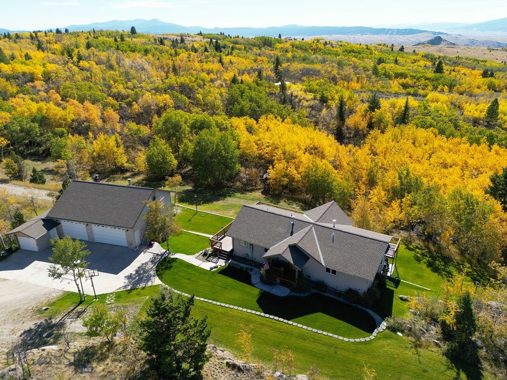 Escape to your own private Montana retreat on 16.93 beautifully wooded acres. This custom-built 2,880 sq. ft. home offers the perfect blend of rustic charm, quality craftsmanship, and modern comfort. Featuring 4 bedrooms and 2.5 bathrooms, the warm all-wood interior was thoughtfully crafted by a master woodworker, creating timeless character throughout.  Designed for both relaxing and entertaining, the home offers expansive mountain views from the large deck, while the  walk-out basement provides additional gathering space for family and friends.  A standout feature of the property is the impressive 5-car garage.  The large shop is in the back of the garage.  There is also a guest quarters upstairs that is already plumbed for water and it offers endless possibilities for visitors, multi-generational living, hobbies, or potential Airbnb use. An attached storage area adds even more room for equipment, tools, and recreational gear. Additional amenities include an air exchange system, reverse osmosis water filtration, radon mitigation, and a full alarm system for peace of mind. Plus, with a newly paved road leading to the property, year-round access is more convenient than ever.  Outdoor recreation is right at your doorstep, with the Moulton Reservoir Nordic Ski trails just down the road—perfect for cross-country skiing in the winter and hiking and biking during the warmer months.  It is just down the road from the Moulton Reservoir, which provides access for fishing, picnicking, and non-motorized watercraft.