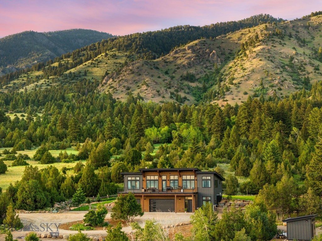 Situated on 20 pristine acres within the highly sought-after Norman Ranches community, this exceptional  custom residence offers a rare blend of natural beauty, thoughtful design, and extraordinary future potential. Evan Reese Creek flows year-round through the property, creating a stunning backdrop of mature trees, lush riparian habitat, and abundant wildlife. Sweeping, unobstructed views span the entire valley, with mountain ranges rising in every direction, delivering a setting that is both inspiring and unforgettable. Designed by Black Mountain Architects to fully embrace its remarkable surroundings, the home is positioned to capture dramatic vistas from nearly every room. Expansive windows frame the landscape like artwork, while the open-concept kitchen, dining, and living areas seamlessly connect to a spacious deck overlooking the creek, rolling acreage, and panoramic valley views beyond. Inside, refined finishes and modern conveniences create an atmosphere that is both sophisticated and inviting. Quartz countertops, a professional six-burner gas range, stainless steel appliances, radiant in-floor heat, automated shades, smart home technology, and carefully curated design elements combine comfort, functionality, and timeless style. What truly distinguishes this property is the opportunity it presents for the future. The septic system was thoughtfully designed to accommodate up to eight bedrooms, supporting both an expansion of the main residence and the addition of a guest home. Existing plans are available for a two-bedroom addition, while the site has already been envisioned for a future shop, barndominium, or separate three-bedroom guest residence. A secondary driveway loop is in place, creating a seamless foundation for future improvements. The outdoor spaces are equally impressive. One acre of fenced lawn and garden area features new sod, trees, and landscaping, complemented by ten raised garden beds, an insulated shed, multiple creek access points, and ample room for recreation, entertaining, and enjoying the property's exceptional natural setting. Neighboring 40 and 160-acre tracts, gated access, and proximity to more than 70,000 acres of National Forest land and extensive trail systems, the property offers a remarkable sense of space and connection to the surrounding landscape while remaining conveniently located less than 25 minutes from Bozeman, Belgrade, and Manhattan, and just 20 minutes from the airport.