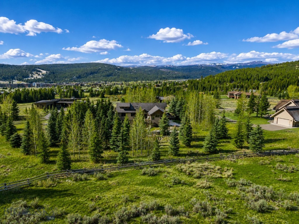 Welcome home to the coveted community of Sweetgrass Hills in Big Sky, Montana. This comfortable five-bedroom residence sits on 1.14 acres in the heart of Big Sky, with mountain views in nearly every direction. Mature trees and extensive landscaping surround the home, two ponds bring a sense of calm to the grounds, and the screening is thorough enough that privacy holds wherever you are, indoors or out.
Inside, the home opens across three levels. Two great rooms anchor the plan beneath high ceilings, with gas fireplaces in both living rooms and the primary suite, and the kitchen brings together granite counters, cherry cabinetry, and stainless appliances with generous room for a slow morning or a full house while entertaining. From there the living space carries outdoors at several turns, where decks wrap the home and a broad concrete patio with a covered hot tub extends the day into the open air. Forced air heat and air conditioning run through every level, and a newer roof tops a home that has been well maintained throughout, making for easy ownership.
Here, your piece of Montana reaches well beyond the home. Town Center sits within walking distance, its restaurants, shops, and gathering spots close at hand, while the skiing at Big Sky Resort, the Nordic trails at Lone Mountain Ranch, and the blue ribbon fishing of the Gallatin are all a short drive away. Within an hour you can reach Bozeman, the gates of Yellowstone National Park, the storied waters of the Madison River, and Bozeman Yellowstone International Airport for easy travel coming and going. A home for a family putting down roots in Big Sky, or a second home with everything the area offers close at hand.