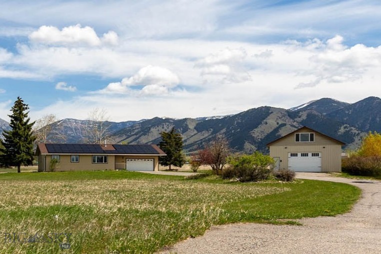 Set against the breathtaking backdrop of the Bridger Mountains, this rare 4.849-acre property offers exceptional versatility, space, and opportunity with no current zoning and no HOA. Whether you’re seeking multigenerational living, rental income potential, a hobby property, or room to spread out and enjoy Montana living, this unique setup delivers.

The property includes a spacious 7-bedroom, 3-bathroom main home plus a detached shop with a separate 2 bedroom apartment and bonus spaces. Inside the main residence, the bright and inviting living room is anchored by a cozy wood stove and framed by windows flooding the space with natural light. The main level also features a dining area and kitchen showcasing stunning mountain views, five bedrooms, and two bathrooms. Downstairs, the finished basement, expands the living space with a large family room, two additional bedrooms (with non-egress windows), and an additional bathroom. Home is equipped with solar panels to keep the utility costs at minimum.

The detached shop building adds incredible flexibility with a large upper-level bonus room where the possibilities are endless - ideal for a home office, gym, recreation room, studio, or guest overflow. Attached to the rear of the shop is a thoughtfully designed 2-bedroom, 2-bath apartment complete with a full kitchen, an additional office/flex room, in-unit laundry hookups, abundant natural light, and beautiful mountain views.

Additional features include a firepit, ample open space, and endless possibilities for how to use and enjoy this exceptional property at the base of the Bridgers.