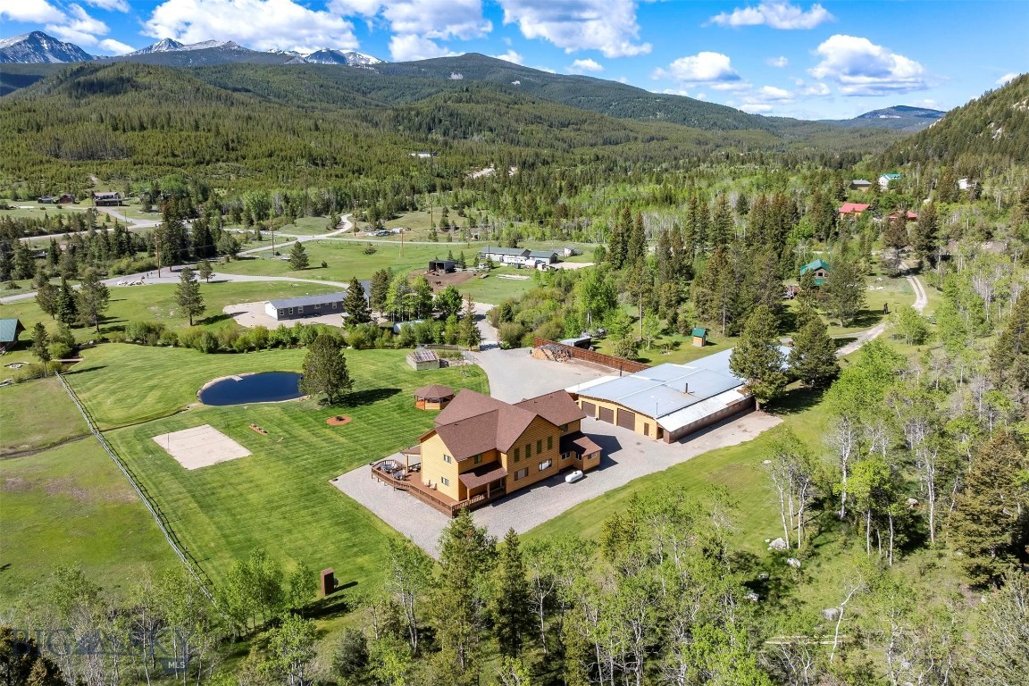 Experience Montana living at its finest on this exceptional 5-bedroom, 3-bath mountain retreat nestled between Anaconda and Georgetown Lake in one of Southwest Montana’s premier recreational destinations. Bordering thousands of acres of Beaverhead-Deerlodge National Forest, this property offers direct access to all sorts of recreation and endless exploration of Montana’s backcountry. Foster Creek meanders through the property, feeding a picturesque trout pond that creates a true park-like setting and attracts abundant wildlife.  Located in the heart of a recreational mecca, you’ll enjoy easy access to Georgetown Lake’s renowned fishing and boating, Discovery Ski Area, Old Works Golf Course, mountain biking trails, and countless opportunities for outdoor adventure. The custom-built home features 5 bedrooms and 3 bathrooms, while the impressive 4,000-square-foot heated garage/shop includes 220 power, a bathroom with shower and abundant space for equipment, recreational vehicles, and all your Montana toys.  Comfort meets efficiency with radiant in-floor heat in both the home and garage, powered by either a wood boiler or propane system.  Fiber Optics so you can work from home!  Anglers will appreciate the opportunity to fish for cutthroat, rainbow, and bull trout right from the pond, while frequent visits from bighorn sheep and other wildlife make every day feel like a private Montana experience.  Whether you’re seeking a year-round residence, recreational getaway, or legacy property, this rare offering combines privacy, recreation, and unmatched access to public lands in an exceptional setting.  A definite must see!