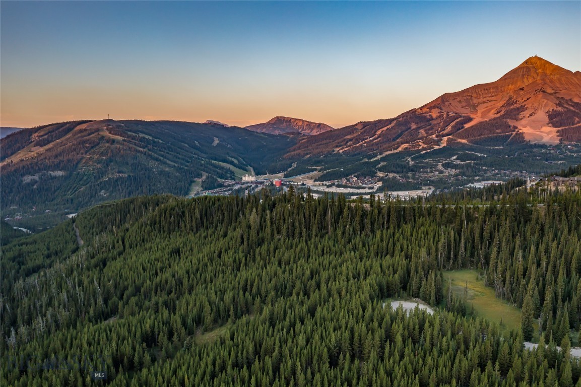 An extraordinary opportunity awaits in Big Sky, Montana: over 7 acres of pristine land showcasing sweeping mountain and valley views, a gently sloped terrain, and the rare privilege of bordering 360 acres of protected conservation land. This striking property offers unmatched privacy at the end of a quiet dead-end road, while still placing you within minutes of Big Sky’s world-class amenities. The neighboring conservation parcel provides unrivaled wildlife viewing and seamless access to low-impact recreation, including direct connections to Forest Service trails that lead deep into Montana’s backcountry.

Adding to its uniqueness, the northeast corner of the property touches a serene tributary commonly known as Beehive Creek, infusing the land with the calming presence of water. From here, you are also within walking distance of the coveted Beehive Basin Trail, one of Big Sky’s most celebrated hikes, offering dramatic alpine scenery and year-round adventure. The setting strikes an exceptional balance of untouched natural beauty and accessibility to Montana’s most sought-after experiences.

The location is simply extraordinary: just 10 minutes to the world-class skiing at Big Sky Resort, 15 minutes to luxury services and fine dining at the first stateside One&Only Resort, 15 minutes to Big Sky Town Center, and 30 minutes to the Montage Big Sky. Beyond Big Sky, you are a scenic hour’s drive to the wonders of Yellowstone National Park, the Yellowstone International Airport, and the historic charm of downtown Bozeman. Here, you’ll experience the rare combination of true mountain seclusion with effortless access to world-class amenities, dining, and cultural experiences.

The property’s flexible land-use opportunities further enhance its appeal. With over 7 acres, multiple structures can be built, allowing you to design an estate that fits your vision—whether that includes a guest house, barn, detached garage, or other spaces to complement your Montana lifestyle. Horses are permitted, opening the door to equestrian living against a backdrop of awe-inspiring mountain vistas.

This is more than a homesite—it is a sanctuary where conservation, privacy, and convenience converge. Whether you’re envisioning a family retreat, a legacy property, or an investment in one of Montana’s most coveted regions, this acreage captures the very essence of Big Sky living.