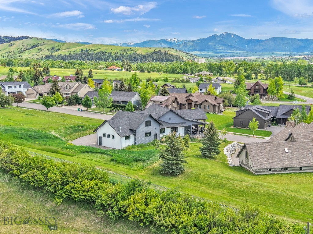 Start 2026 strong with a rare opportunity to live beautifully while your home works for you. This exceptional luxury residence includes a high-performing ADU generating up to $7,100 per month, offering a powerful combination of lifestyle and income. Set in the scenic foothills of the Bridger Mountains, just north of Bridger Creek Golf Course, 557 St. Andrews Drive captures the essence of Bozeman living—privacy, convenience, and sweeping views of the Bridger, Gallatin, and Spanish Peaks. With nearly 5,700 square feet of thoughtfully designed space, this custom home offers 6 bedrooms and 4.5 bathrooms, including a private third-level guest suite currently operating as a successful short-term rental. Ideal for visitors or income generation, the guest quarters are accessed through a shared oversized mudroom, providing separation without sacrificing ease of use. The main level is light-filled and inviting, featuring soaring ceilings, oversized windows, and an open-concept layout designed for both everyday living and entertaining. The showpiece kitchen is outfitted with Monteriors quartz countertops, gold and white Café appliances, and a refined aesthetic curated by Sanctuary Interior Design—complete with designer lighting, wallpaper, and hand-selected furnishings. A formal dining room, dedicated office, expansive entertaining deck, and a serene primary suite with dual walk-in closets and a spa-like en suite complete this level. A striking cantilevered staircase with glass balustrades leads to the lower level, where you’ll find a second living area, three additional bedrooms, two full bathrooms, and a flexible space ideal for a gym, playroom, or creative studio. Outside, unwind in the hot tub while soaking in panoramic mountain views. Additional features include a three-car attached garage, dual water heaters, generous storage, and quality craftsmanship throughout. Just minutes from Downtown Bozeman, Bridger Mountain trails, and year-round outdoor recreation, this home seamlessly blends refined design, income potential, and Montana’s natural beauty.