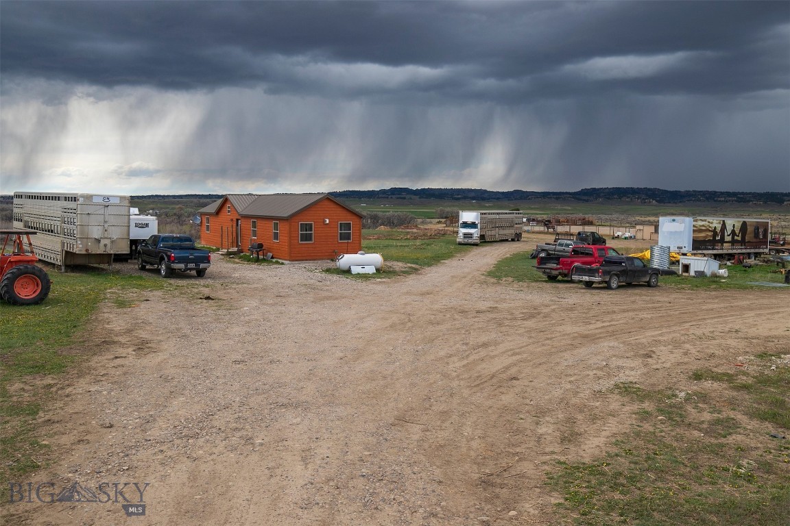 The wide stretch of nearly seventy acres opens with a sense of calm as the land rises and falls toward the distant river. A welded pipe arena sits ready for animals to move through it, with a working pen and holding pen nearby. A tack room and mini barn offer useful places to store gear and supplies. The cabin at the heart of the property brings a warm glow with its knotty pine interior. A bedroom sits on the main level, while a sleeping loft adds extra space. Fields along the lower edge of the property are irrigated with water from the Custer Waco Ditch Rights, and fencing surrounds the acreage for managing livestock. From the rim top, the view stretches over the land below and toward the Yellowstone River. An old train tunnel, long unused, rests quietly on the property. Access to the interstate is nearby, and Billings is about an hour away. The setting offers room to work, explore, and enjoy the rhythm of open land.