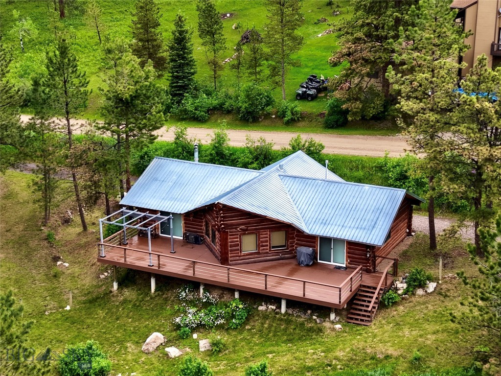 Set among the ponderosas just off Highway 89, this log home on Sun Mountain Drive captures views of the Little Belt Mountains and borders thousands of Forest Service acres. A wide wraparound deck opens the home to the pines and the afternoon light. Inside, a wood stove anchors the space with warmth that suits the setting, while solid log construction and a metal roof stand ready for every season this country is known for. At 1,724 square feet with two bedrooms and a bath, the cabin lives easily as a year-round home or a basecamp for everything Monarch puts within reach — Showdown Ski Area and its groomed Nordic trails, the trout pools of Belt Creek, hundreds of miles of snowmobile and motorized routes as well as hiking trails, and some of central Montana's finest hunting just beyond the door. An oversized detached two-car garage, fenced yard, and the option to take it fully furnished make the move a simple one. Enjoy this property year-round from a plowed and maintained county road.