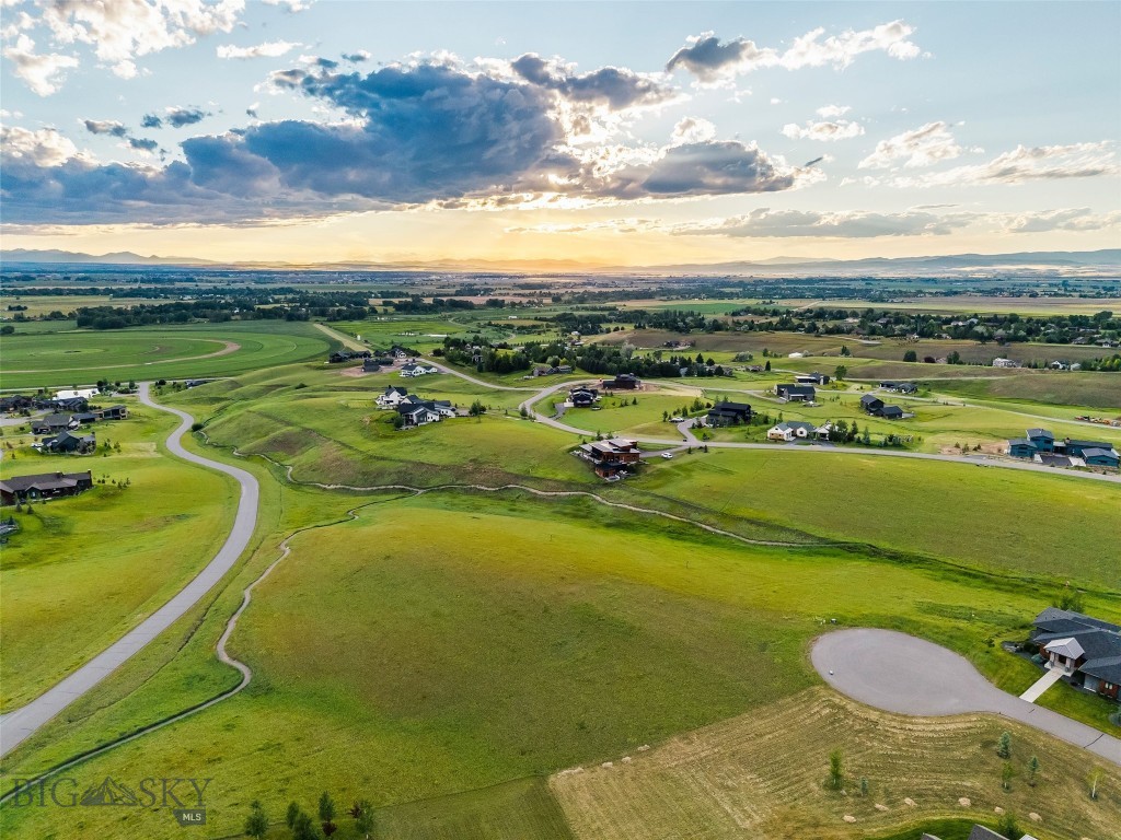 Perched at one of the highest vantage points of the prestigious Springhill Reserve subdivision, this premier lot on Rustic Rock Drive offers what is undeniably the most spectacular, unobstructed view of the entire valley. Flanked by protected open space on two sides, this elevated position treats your eyes to a dramatic, 360-degree Montana panorama: the rugged, snow-dusted peaks of the Bridger Mountain Range dominate the immediate backyard, while the distant, jagged silhouettes of the Spanish Peaks and the Tobacco Root Mountains frame the sweeping horizon. Below you, the vast, rolling expanse of the Gallatin Valley stretches out in a patchwork of emerald fields and big-sky country, giving way to the twinkling city lights of Bozeman as twilight sets in. Perfectly balancing high-alpine tranquility with exceptional urban convenience, Springhill Reserve offers an idyllic lifestyle where Montana's premier amenities are practically at your doorstep. Adventure awaits just minutes away with world-class skiing at Bridger Bowl Ski Area and pristine Nordic Trails at Crosscut Mountain Sports Center, and panoramic hiking right down the road at the iconic College "M" Trail. For leisure and socializing, the Riverside Country Club sits just a short drive down the road, offering a championship golf course, tennis, and fine dining. A brief 15-minute drive delivers you to the vibrant energy of downtown Bozeman, celebrated for its eclectic culinary scene, boutique shopping, and rich cultural charm. Additionally, the Bozeman Yellowstone International Airport is an easy 20-minute drive via quiet backroads, ensuring that whether you are hitting the slopes, heading out to dinner, or catching a flight, everything you need is seamlessly within reach.