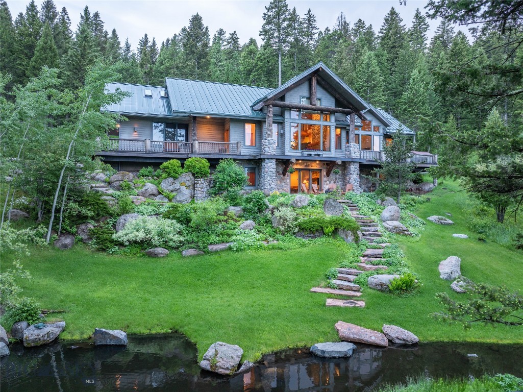 Welcome to one of the most special properties in Eagle Rock Reserve. One of only six alpine lots in the community, this 20-acre retreat is tucked among towering evergreens, wildflowers, and two tranquil ponds with cascading water features, creating a private, park-like setting just 15 minutes from downtown Bozeman.  Designed by renowned architect Faure Halvorsen and built by respected Bozeman craftsman Jim Syth, the 4,516 SF custom home blends mountain architecture with warmth and livability. Expansive windows frame Bridger Mountain views, while the rest of the home sits quietly within a canopy of mature forest, offering a true Montana retreat.  Inside, vaulted ceilings, rich wood detailing, and a dramatic floor-to-ceiling stone fireplace anchor the great room. The thoughtful layout includes a main-level primary suite, a walk-out lower level with guest bedrooms and family room, and a light-filled loft with office or studio spaces, ideal for creative work or remote living.  Outdoor living is equally special, with a wraparound deck, covered patio, and peaceful seating areas woven into the landscape.  Residents of Eagle Rock Reserve enjoy access to a private equestrian facility, stocked trout pond, maintained trails, and adjacent State Land, with nearby access to Triple Tree Trail and National Forest.  A rare alpine sanctuary where privacy, craftsmanship, and the Montana landscape come together, just minutes from Bozeman.