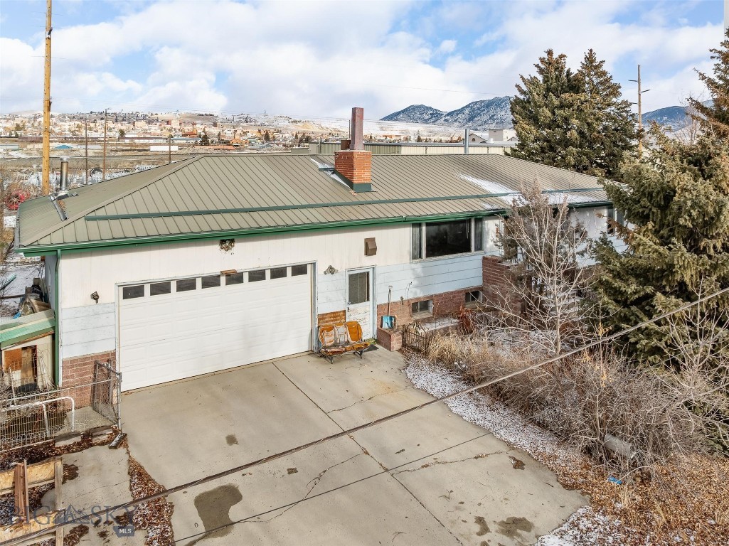 Property is a two level ranch style home with a newer metal roof.  Enter from main level to upstairs living room with wood insert fireplace. Kitchen is U shaped with eating area.  Laundry room is off the hallway along with a full bath and hall closet.  There are two bedrooms on the main level with large closets.  On the north side of the house is a play room and sun room and a covered deck.  On the lower level there is a family with a wood insert fireplace, wet bar and non conforming bedroom.  In addition is a full bathroom with washer and dryer hookups.  Extensive storage areas under the decks and garage.  The property has a two car garage.
