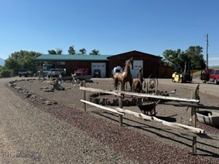 Rare opportunity to own this highly versatile 3 acre live/work property seldom available in the Ennis market.  The improvements total approximately 5,559 sq ft under roof including the main shop, attached living/office space, loft, storage area and utility room.  Currently configured for RV Repair, the improvements and flexible layout are adaptable to support numerous commercial, industrial, residential and investment uses.  The property is in a private setting with expansive views of Ennis Lake, Madison River drainage, and Madison Range. 

SHOP: 
The main shop is 3,676 Sq foot under one roof. The shop includes two spacious work area/bays to accommodate large vehicles and equipment.  One large work area/bay, which is 40 x 56 (or 2,240 sq ft) with a 14 X 14 garage door, a 6-foot pit for under carriage work, a 600 sq ft loft, and floor-to-ceiling industrial shelving.  The second work area/bay is 29 x 44 (or 1,276 sq ft) with a 12 x 12 garage door.  In addition, there is a utility storage room (240 sq ft) and storage shed (340 sq ft) attached to the main building.

LIVING AREA: 
The attached living area of 704 sq ft provides office space, kitchen, full bath and laundry facilities. In addition, this area offers excellent potential for expansion into a larger residence. Adjacent to the living area is a 660 sq ft concrete carport. 

OUTSIDE:
The property lot is all gravel with ample parking/storage for recreational/utility vehicles, work trucks, boats, RVs and more.  There are both 30- & 50-Amp RV hookups.  There is a 500-gallon leased above ground propane tank, a 28-panel solar array, which helps offset electrical costs. The property is served by a private well, producing 40 GPM and private septic system.

PROPERTY/AREA INFORMATION: 
This property is located near Ennis, in the heart of the Madison Valley.  You are minutes away from world-class fly fishing on the legendary Madison River, with easy access to hunting, hiking, skiing in Big Sky, snowmobiling, and horseback riding. The entire Madison Valley is surrounded by public lands. Ennis offers a welcoming small-town atmosphere, excellent amenities, and spectacular scenery while remaining within easy reach of Bozeman, Big Sky and Yellowstone National Park. Properties offering this combination of acreage, commercial improvements, expansion potential, and Madison Valley location are seldom available.
