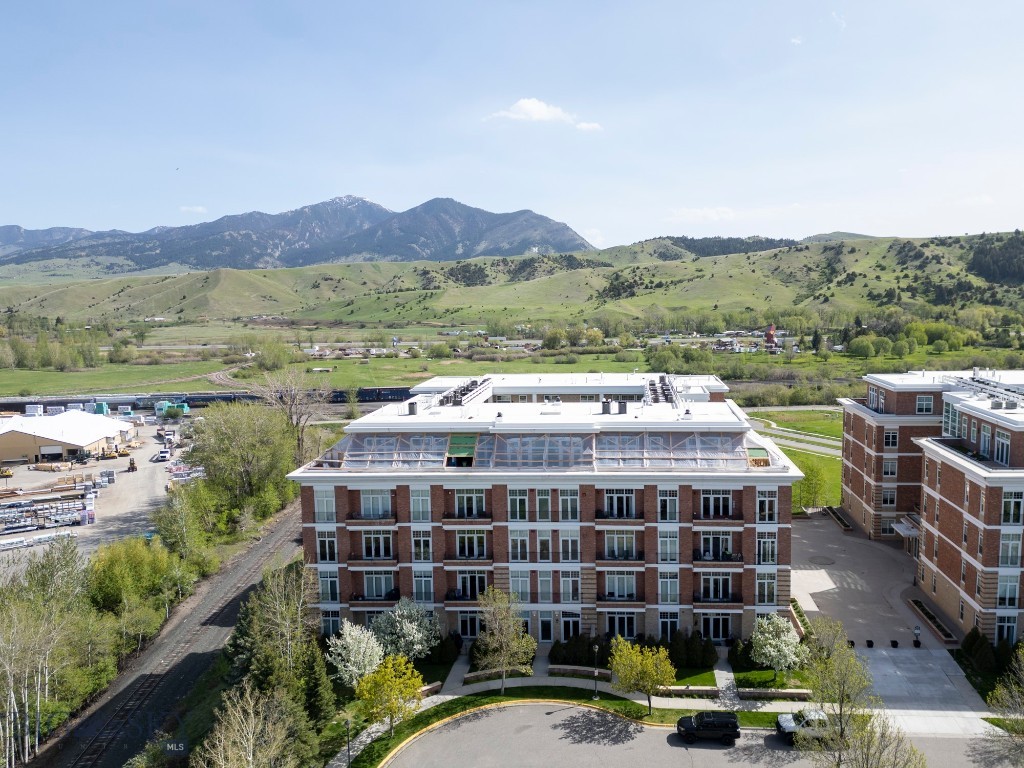 Easy living in downtown Bozeman! This lightly lived-in 2 bed/2 bath third floor condo offers stunning Bridger Mountain views and quick access to dining, breweries, coffee shops, parks, and more. It features upgraded finishes and lighting, 12-foot ceilings, great natural light, hardwood floors, stainless steel appliances, a gas range, granite countertops, a beverage/wine fridge, a coffee/cocktail nook, a hallway book case, plus a desk and cabinets. The master suite has dual vanities, an oversized walk-in tile shower, and a soaking tub. A separate guest bedroom has a Murphy bed and an adjacent full bathroom. For those cold and cozy winter months, enjoy the gas fireplace and in-floor radiant heat. And of course there is central AC for when you need to cool down. Finally, you have private access to a climate-controlled garage parking spot with a storage unit and an adjacent electrical outlet and wall that can be utilized for certain storage which is conveniently located near the elevator and stairs.  Contact us or your favorite realtor to schedule a tour!