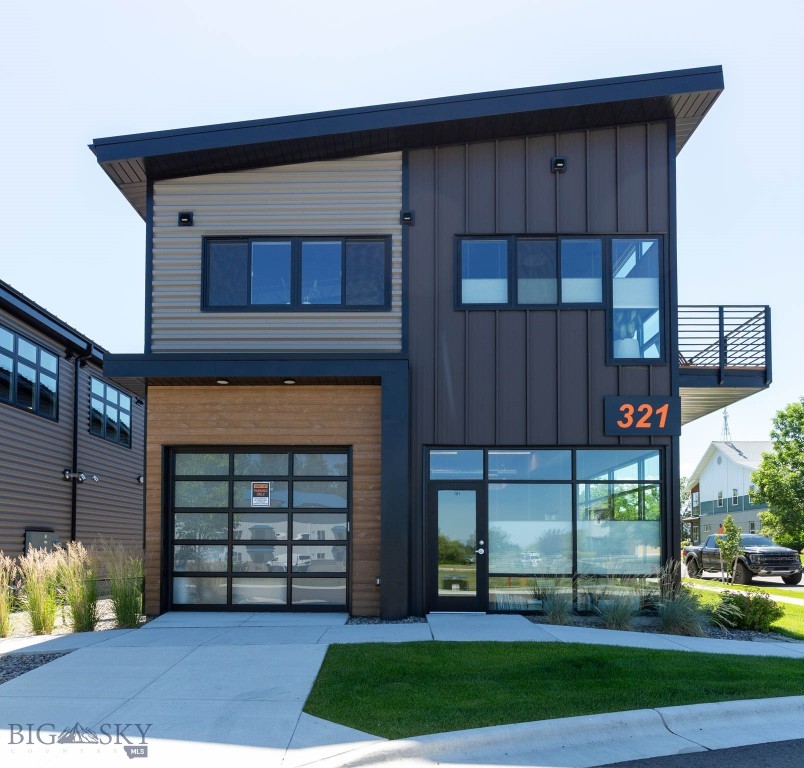 Discover the perfect blend of modern living and exceptional workspace in this newer live/work condo offering a rare combination of flexibility, style, and functionality. Designed with today's lifestyle in mind, this unique property features an expansive 1,333 sq. ft. garage/shop on the main level complete with a convenient half bathroom—ideal for a variety of businesses such as a bridal shop, real estate brokerage, yoga studio, interior design showroom, consulting firm, professional office, salon, artist's studio/gallery, contractors workspace, or for your personal hobbies or storage needs.  Upstairs, you'll find 1,327 sq. ft. of bright, thoughtfully designed living space filled with abundant natural light from oversized windows. The open-concept floor plan showcases contemporary finishes, air conditioning for year-round comfort, and a spacious kitchen with ample cabinetry, generous counter space, and an oversized island that seamlessly connects to the dining and living areas—perfect for entertaining or everyday living. Just off the main living area, a spacious second-floor deck extends your living space outdoors, creating the perfect spot for morning coffee, evening relaxation, or gathering with family and friends. The upper level also offers two comfortable bedrooms, a full bathroom, and a dedicated office, providing the flexibility to work from home or create a quiet retreat. Three designated parking spaces add even more convenience for owners, clients, or guests. Whether you're looking to operate your business below, enjoy an incredible workshop, or simply appreciate the versatility of a live/work design, this modern condo delivers a rare opportunity to own a space that adapts to your lifestyle.