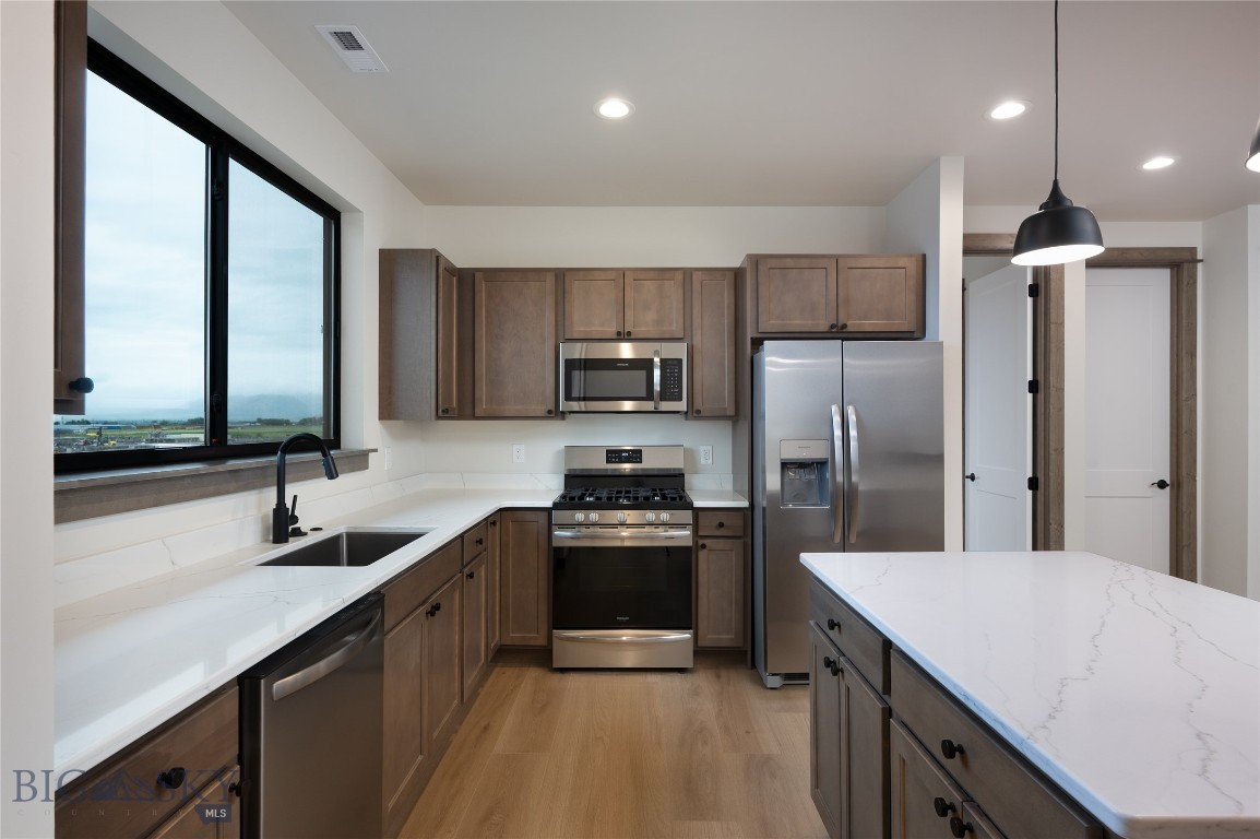 The Cottonwood Flex Plan at Fremont Square is designed for owners who want additional workspace without sacrificing flexibility upstairs. Offering approximately 2,671 square feet, the main level includes 1,286± SF of commercial space with 15-foot ceilings, a 12' x 14' overhead door that is a pull through to the other side of the building, and an ADA-compliant bathroom. The upper level provides 1,385± SF of flexible space that can function as an office suite, studio, or apartment with two bedrooms plus a open flex room that can serve as an office or separate living room. This plan features a large, south facing, 230 sq ft deck that spans the main bedroom and flex room. Located along Jackrabbit Lane near the new Jackrabbit Crossing development, Fremont Square delivers excellent visibility and access to I-90, Bozeman, Belgrade, and Big Sky. A perfect setup for trades, small businesses, hobbyist, or light industrial users seeking ownership with built-in versatility.