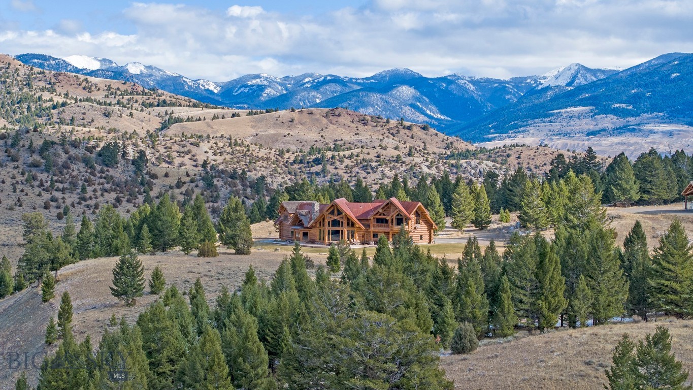 Step into a world straight out of “Legends of the Fall” on this breathtaking 86+/- acre property nestled deep within Montana’s pristine Cinnabar Basin. As you pass through the entryway arch, your eyes will delight in their surroundings and you will feel as though you have been transported to another world—one where life is as peaceful as the creek babbling throughout the property. Just minutes from Yellowstone National Park, this private mountain retreat offers a rare opportunity to own a slice of the American West which most can only see on television. This remarkable Cinnabar Basin sanctuary was originally settled by one of the first ranching families to arrive in Paradise Valley in the 1800’s, and now it can be yours. The main lodge features a magnificent 4379 sqft (basement sqft excluded) primary residence including a grand entrance opening to a living area framed by massive windows and showcasing unparalleled views. As you move to the left, you will find a rustic yet thoughtfully designed gourmet kitchen, inviting communion with its gorgeous finishes and large welcoming island. Ascend the curved staircase to the second floor and an oversized hallway leads you to multiple bedrooms and bathrooms, providing ample space for overnight guests. Three cabins are scattered throughout the property and could be utilized as rentals or a family compound. Just a short walk from the main home, and at the property’s highest point, you will find a world- class riding arena with beautifully crafted stables and newly finished living quarters. This area of the property also includes an airstrip which lies near the arena, once used for landing small aircraft. Downhill and private from the primary residence rests a log-sided barn suitable for storage, a workshop, or conversion to an additional living quarters. Located just 30 minutes from Gardiner and 80 minutes from Livingston, this retreat offers both seclusion and accessibility. There are plenty of amenities nearby so you will never run out of activities to enjoy! Whether you’re seeking a permanent residence, a multi-generational family compound, or an exclusive vacation getaway with rental potential, this property has it all. Here, you will enter an unparalleled living experience where the spirit of the West is thriving.